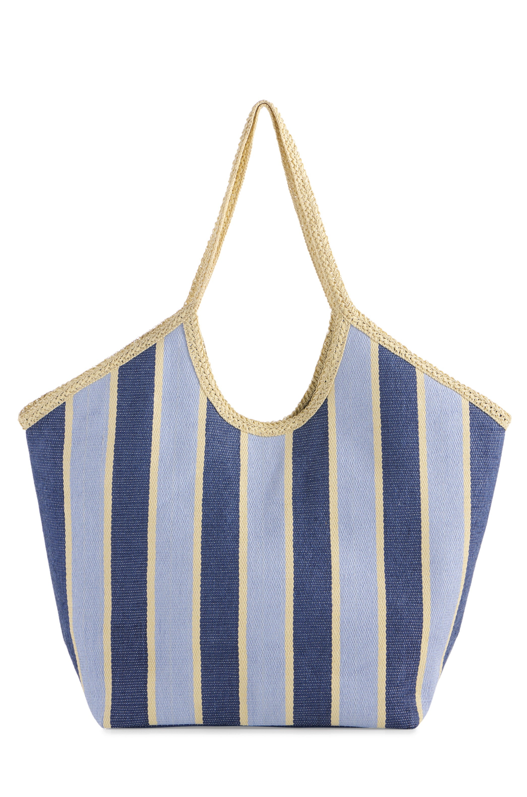 The South Moon Under Capri Tote is a spacious beach bag with wide vertical stripes in light blue, navy blue, and beige, finished with beige woven handles and trim.