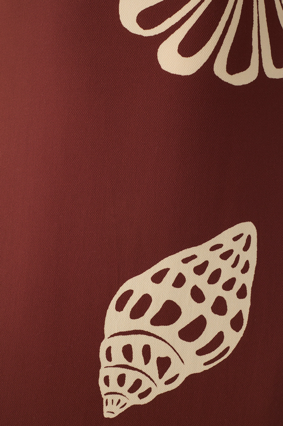 A maroon background with cream-colored seashell and flower cut-out illustrations—an ideal backdrop to highlight the Brown Maritime Cut-out Smocked Maxi Dress by Dress To.