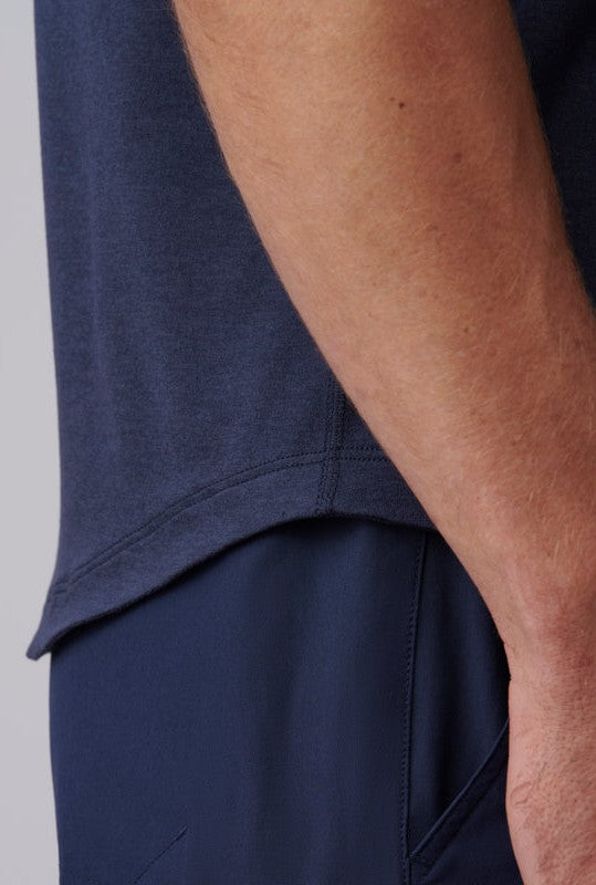 Close-up of a person's arm and torso wearing the South Moon Under Atmosphere Tee in dark blue and navy pants, with their hand by their side. The image highlights the shirt’s side seam and hem.