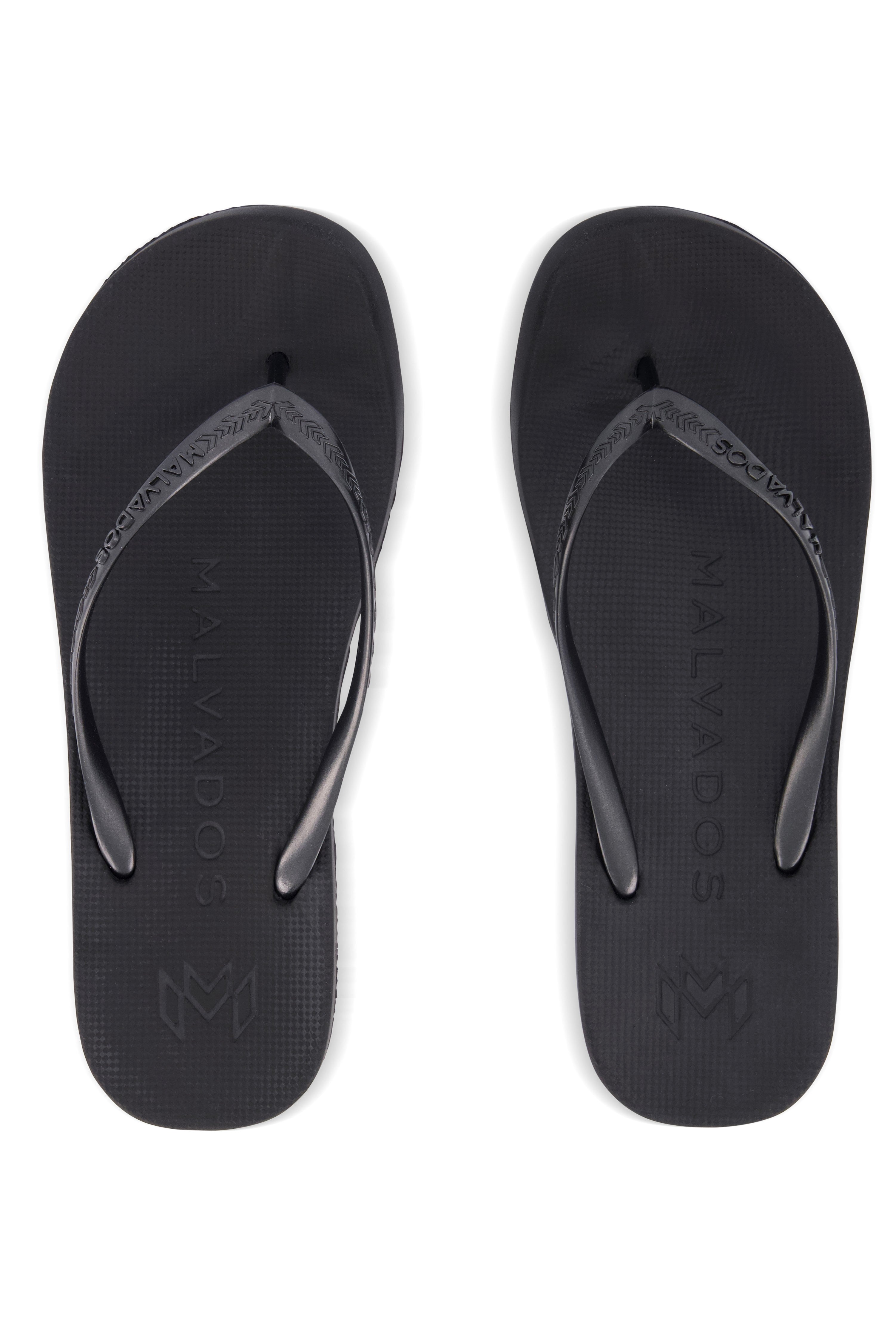 The Malvados Playa Onyx Flip Flop features quick-dry uppers, textured footbeds, black straps, and the Malvados name embossed on the soles.