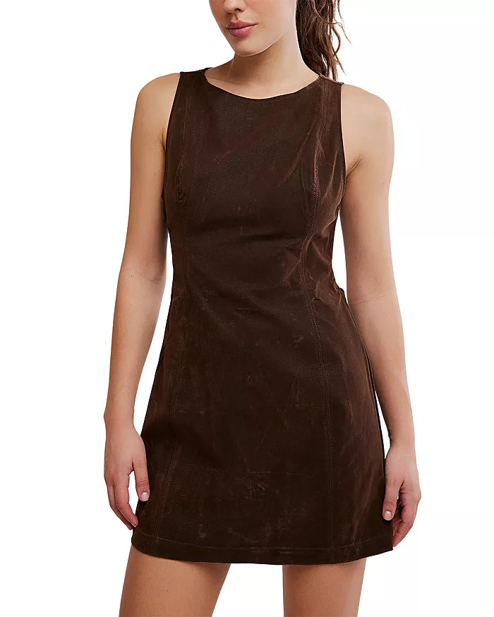 A woman stands facing forward against a white background, arms relaxed at her sides, wearing the Free People Atlas Suede Mini Dress—a sleeveless, fitted dark brown mini dress featuring a subtle back cutout.