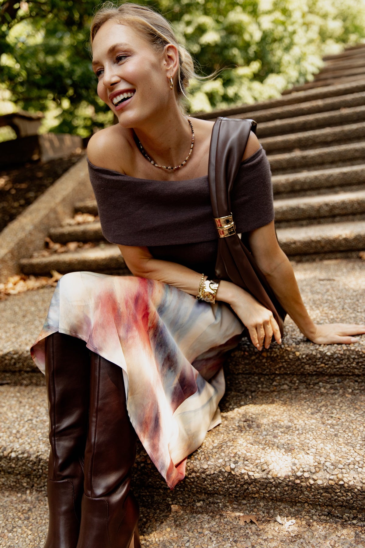 Cream satin skirt with red and blue watercolor streaks, worn with dark brown top and boots.