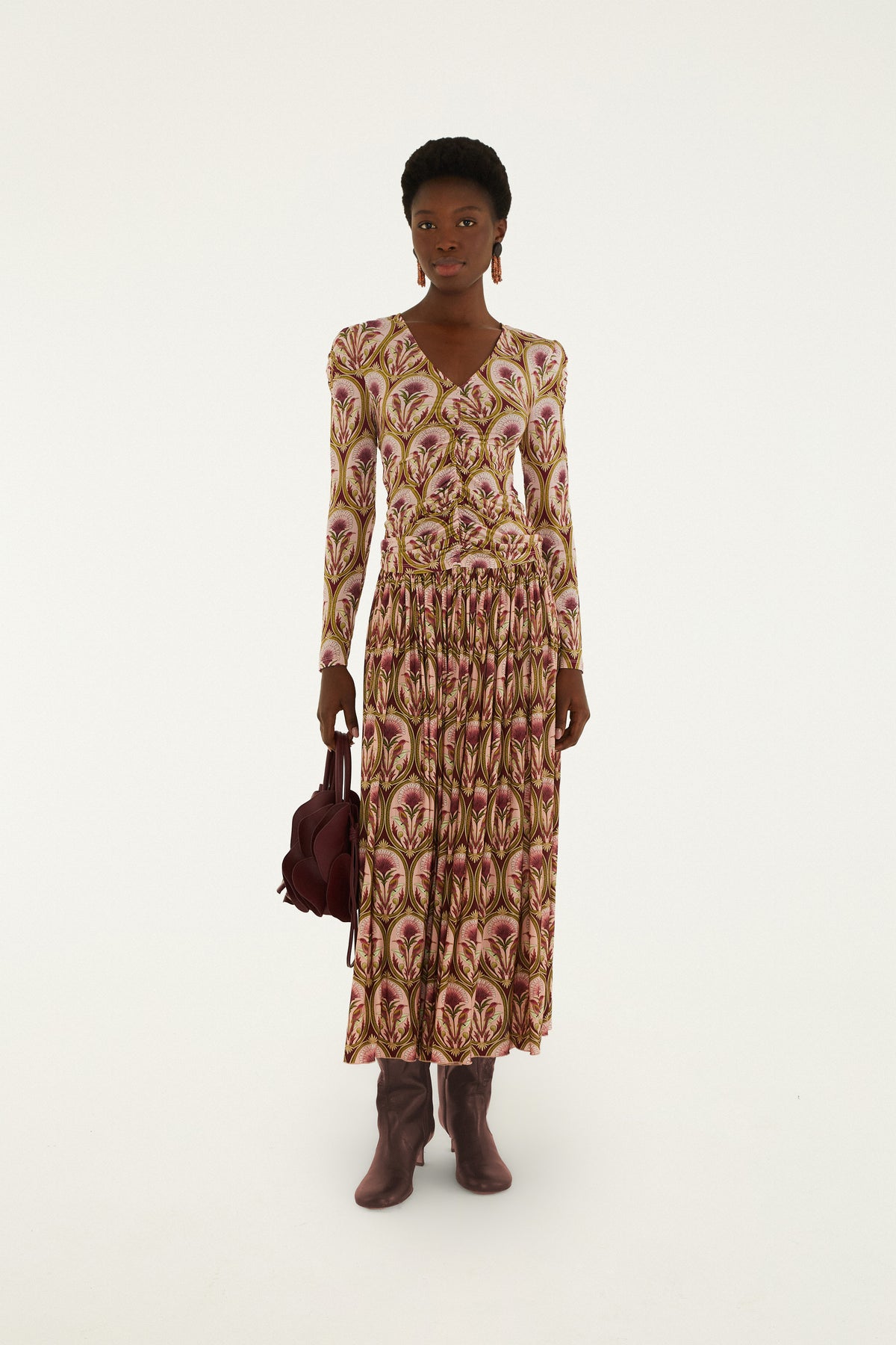Multicolor floral print long sleeve blouse with V-neckline and pleated skirt detail in gold, pink, and cream tones.