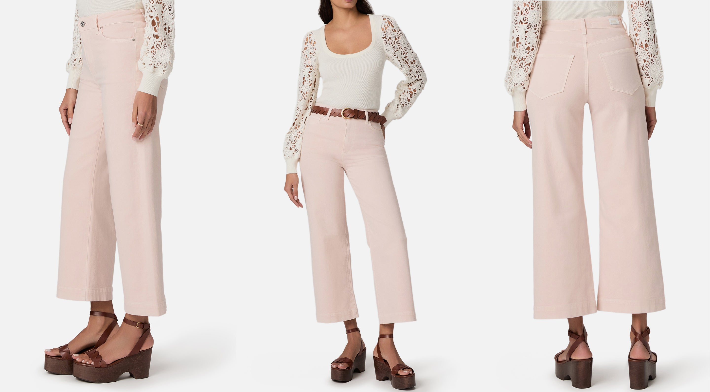 Woman wearing a white lace top and light pink pants with a belt, standing against a white background.