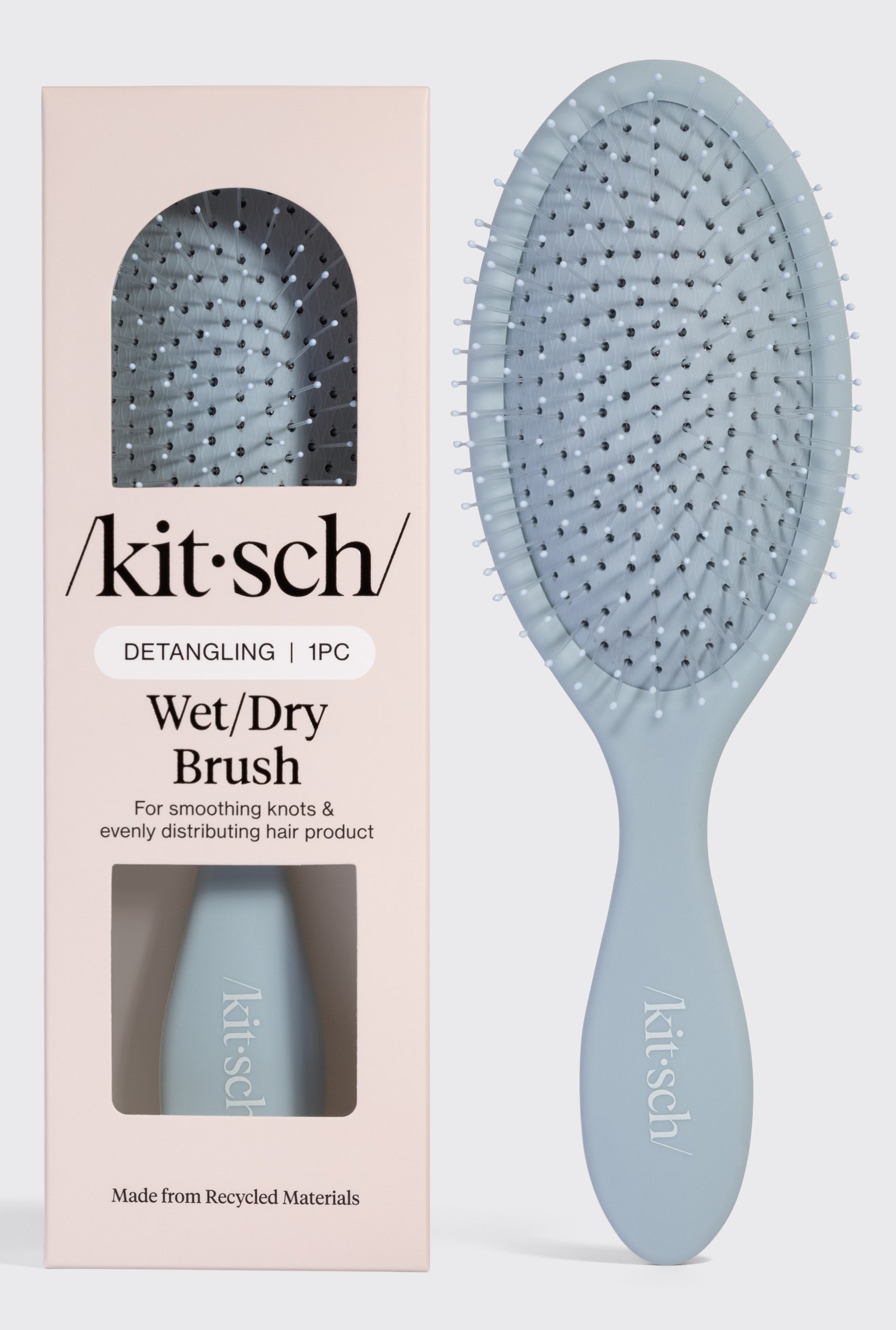 A blue Kitsch Wet/Dry Brush is shown inside its packaging and next to the box, which reads: Detangling Wet/Dry Brush—for all hair types, smoothing knots, frizz-free hair, and evenly distributing product.