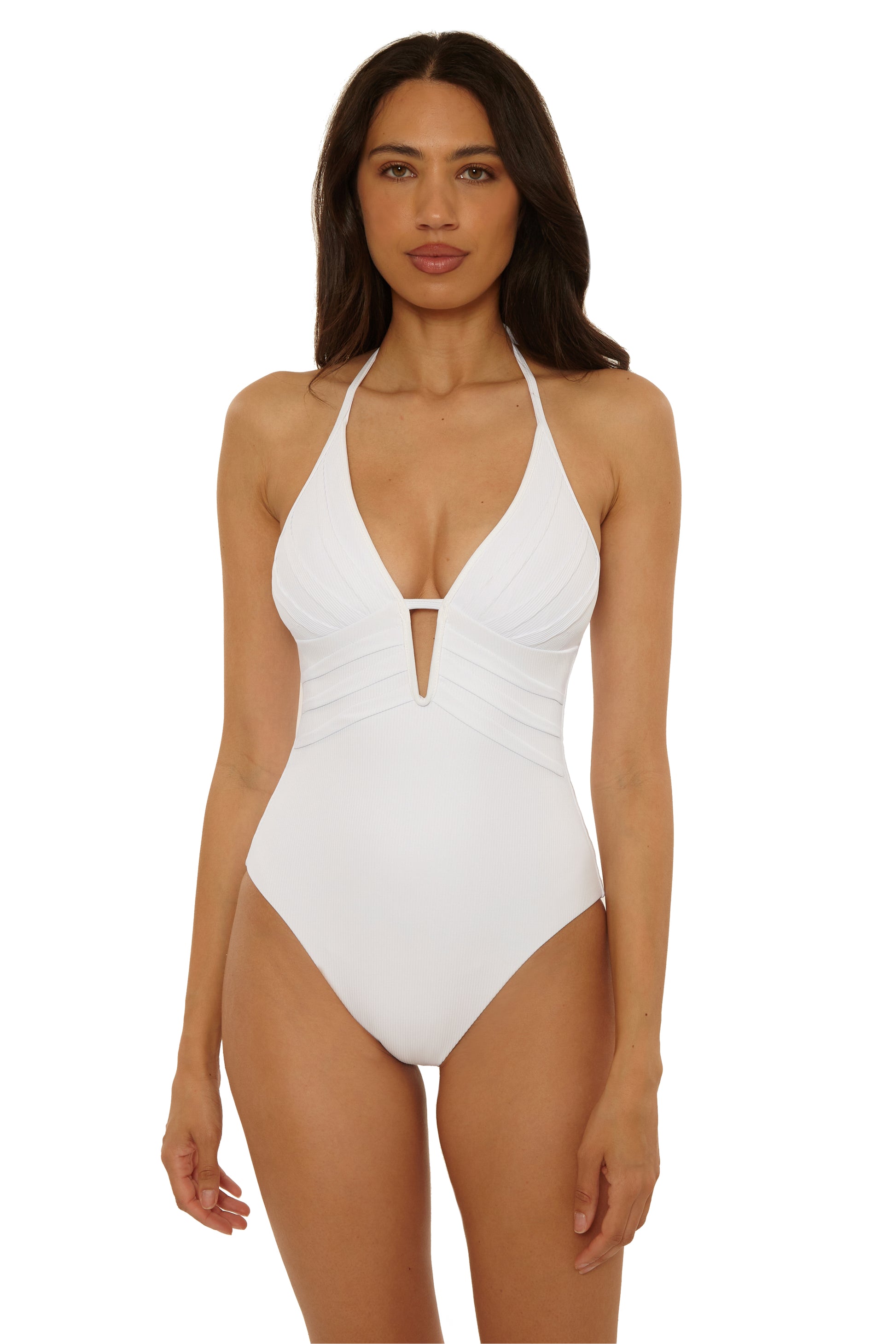 A woman with long dark hair models the Modern Edge One Piece by Becca Swim—a white nylon-spandex swimsuit featuring a halter neckline, adjustable tie straps, and moderate back coverage—against a plain white background.