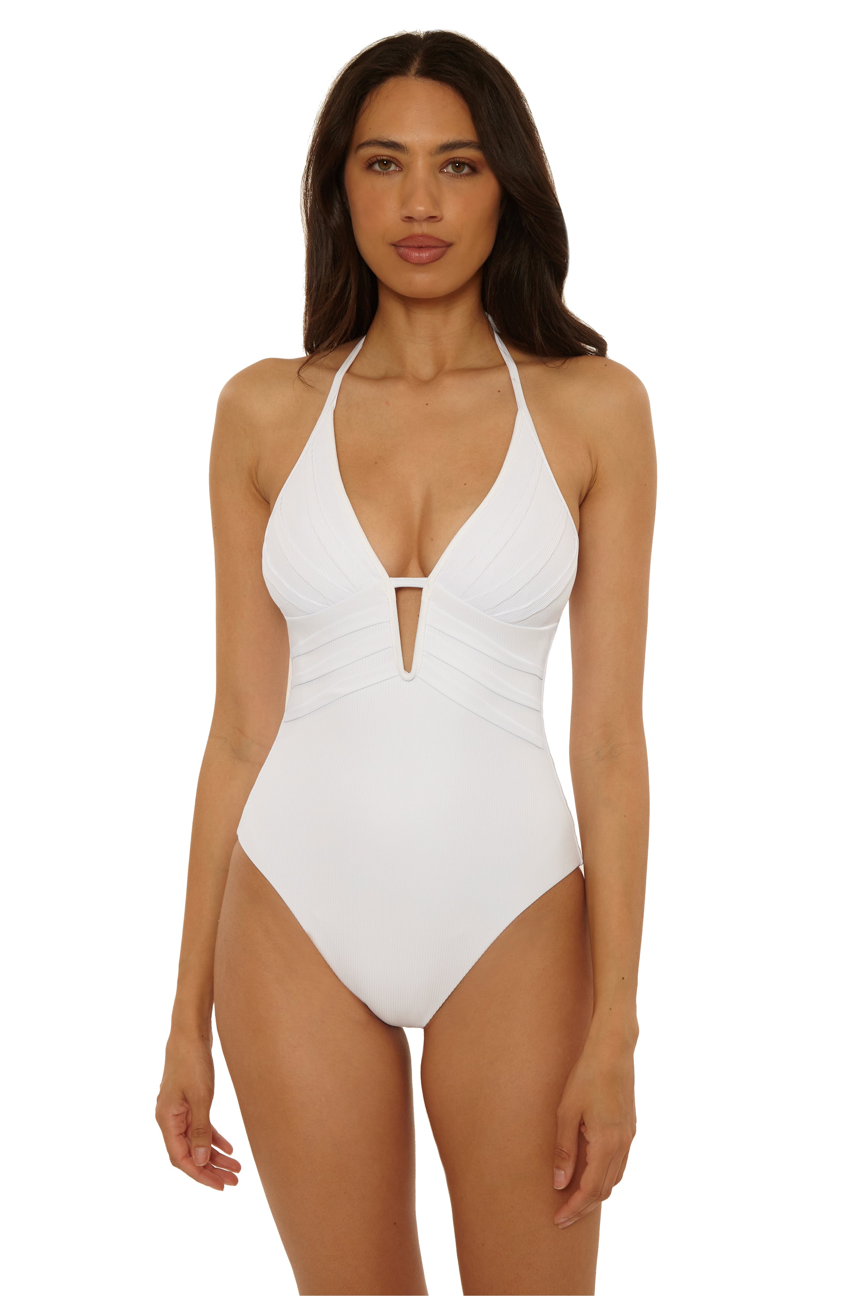 A woman with long dark hair models the Modern Edge One Piece by Becca Swim—a white nylon-spandex swimsuit featuring a halter neckline, adjustable tie straps, and moderate back coverage—against a plain white background.