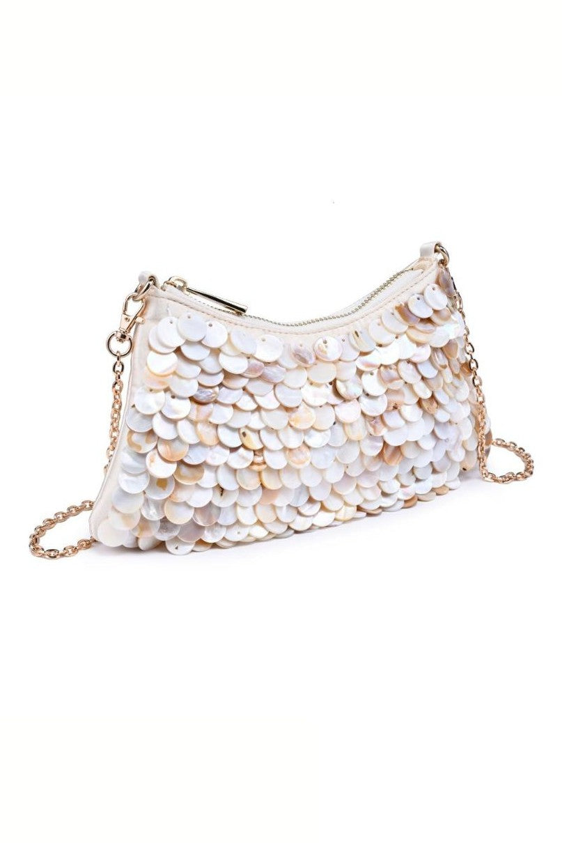 The Opalite Shell Purse by Urban Expressions is a small white satin clutch adorned with shiny circular sequins and a removable gold chain strap, shown against a white background.