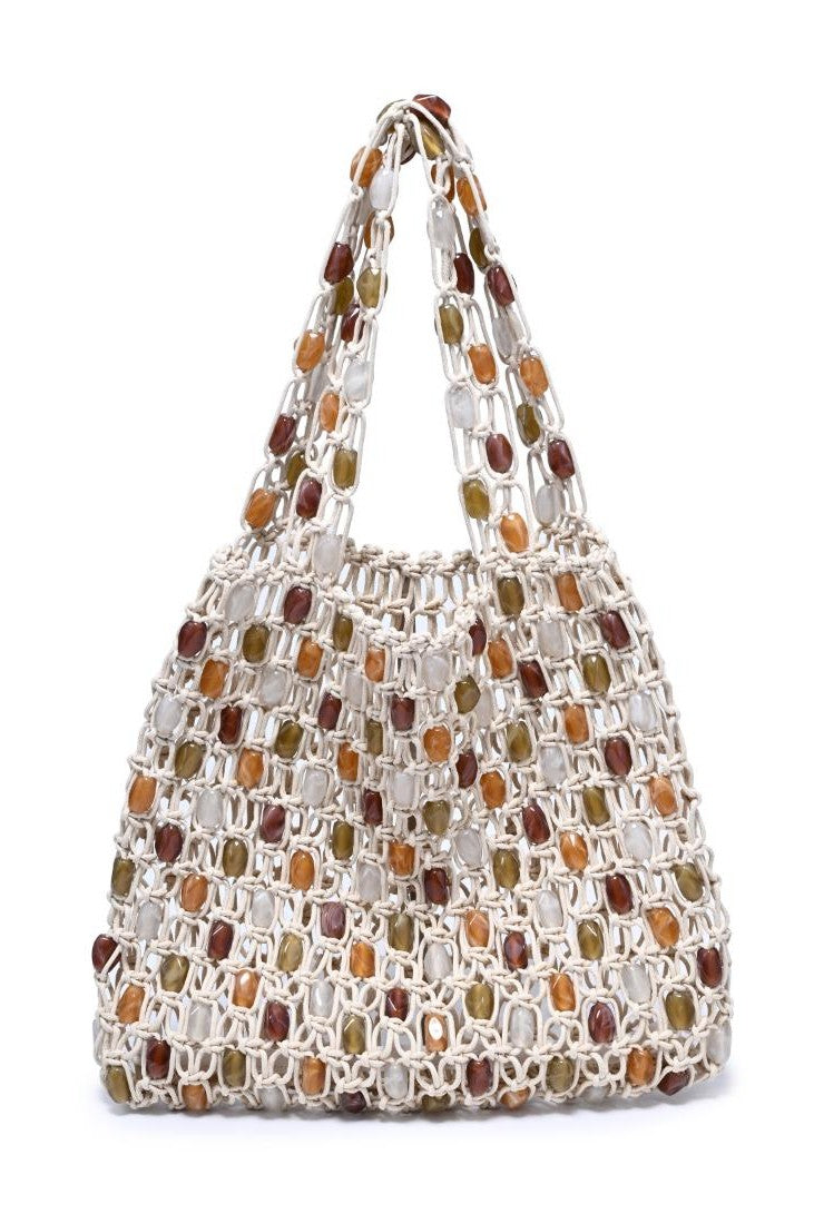 The Asher Beaded Beach Bag by Urban Expressions is a white woven macramé tote with two handles, featuring brown, amber, and olive green square beads in a grid-like, see-through design—a stylish boho accessory for any occasion.