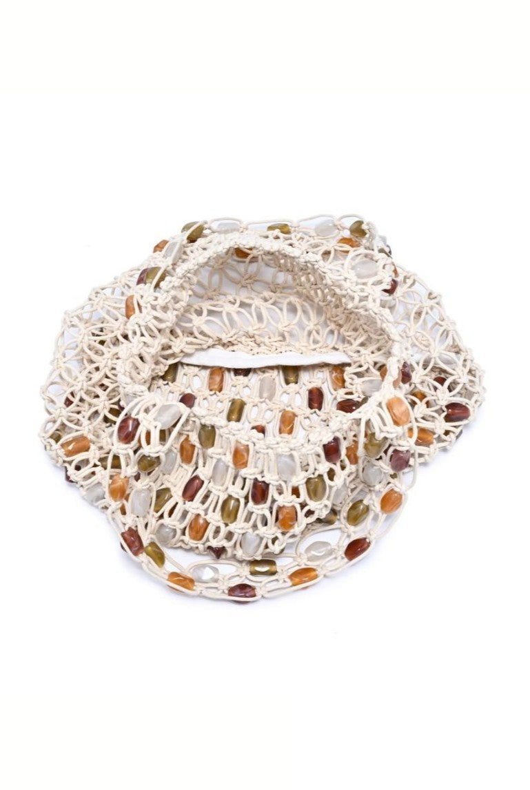 The Asher Beaded Beach Bag by Urban Expressions features a cream-colored woven macramé design with an open, circular pattern and multicolored beads in amber, olive, and brown.