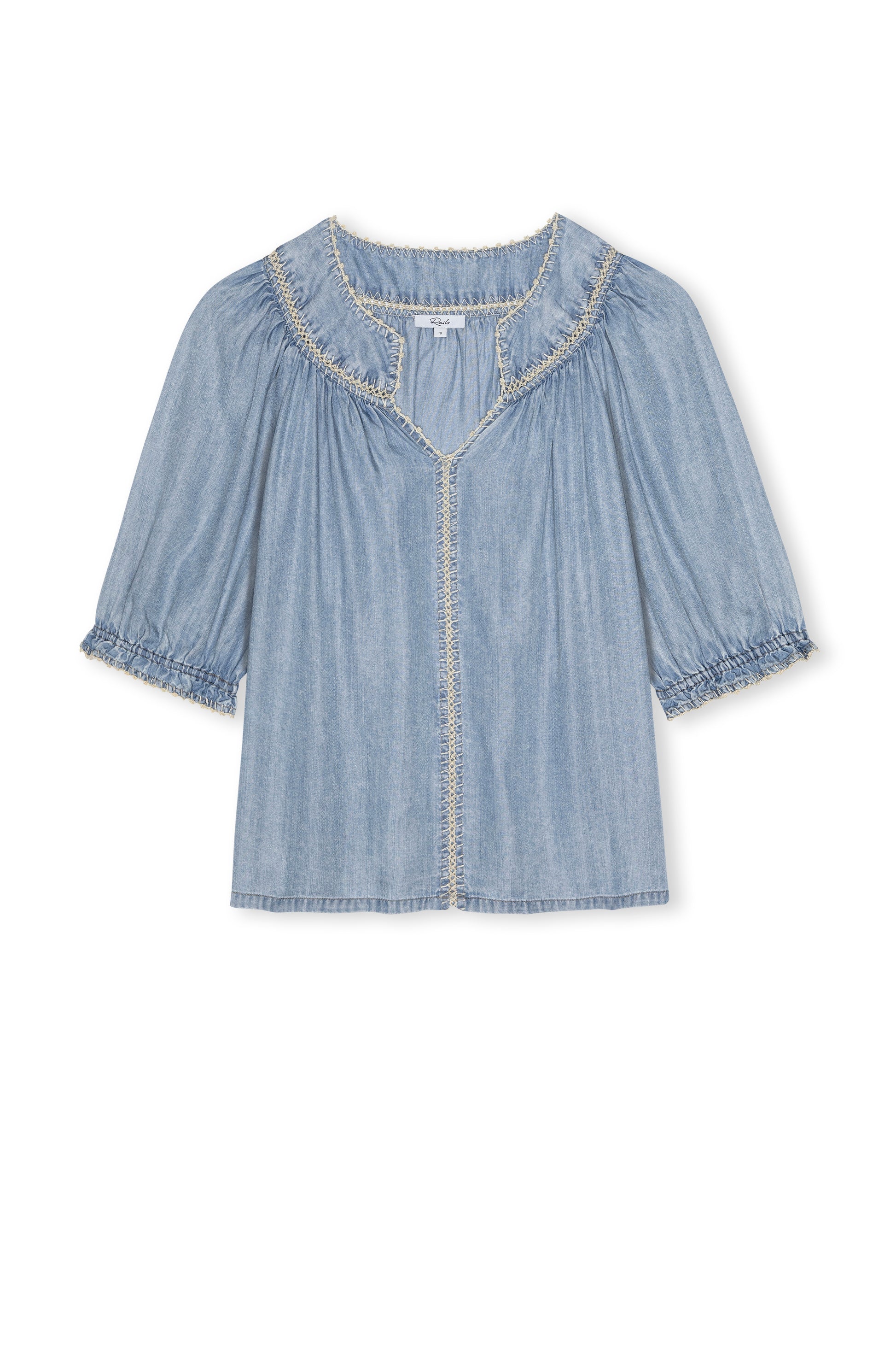 The Belina Short Sleeve Denim Top by Rails is crafted from light blue ultra-soft TENCEL, featuring ruffled trim on the collar, sleeves, and front with a loose fit and gathered neckline and sleeves for effortless charm.