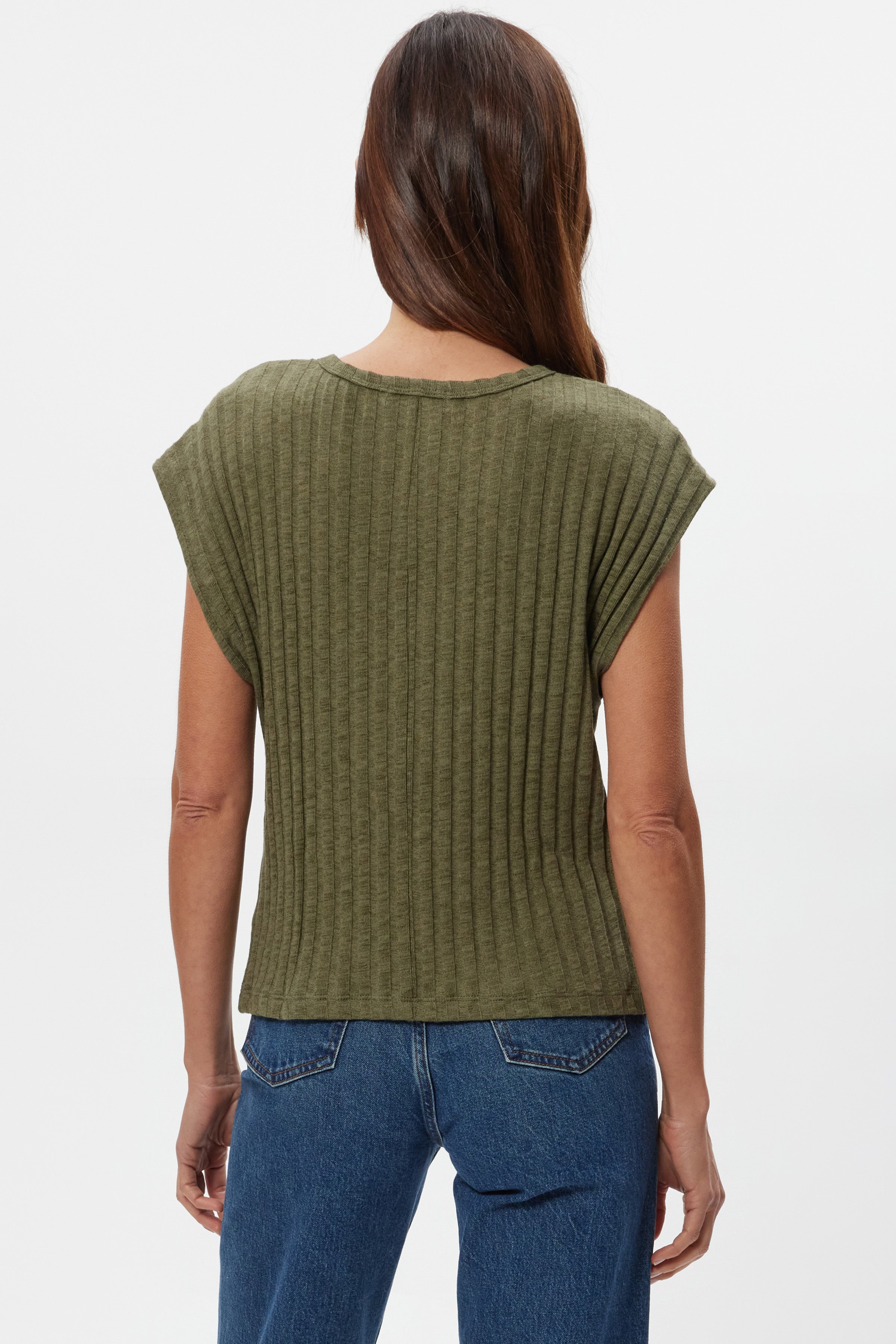 Woman with long brown hair wears the Michael Stars Jinny Power Shoulder Top in olive green with blue jeans, shown from the back against a plain white background.