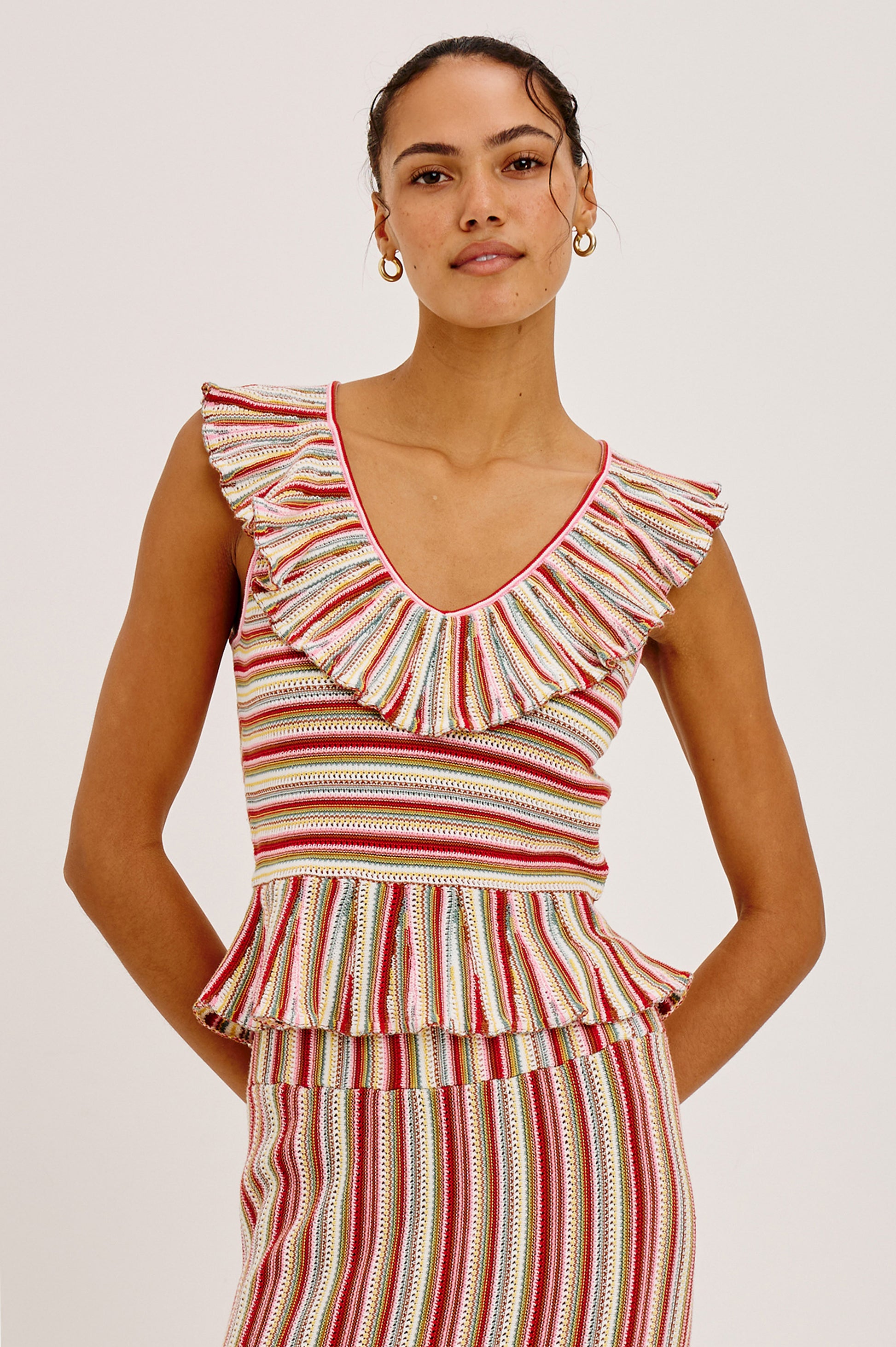 A woman models the Rails Carmelita set—sleeveless, ruffled V-neck top and matching skirt with red, white, and yellow vertical stripes—against a plain light background.
