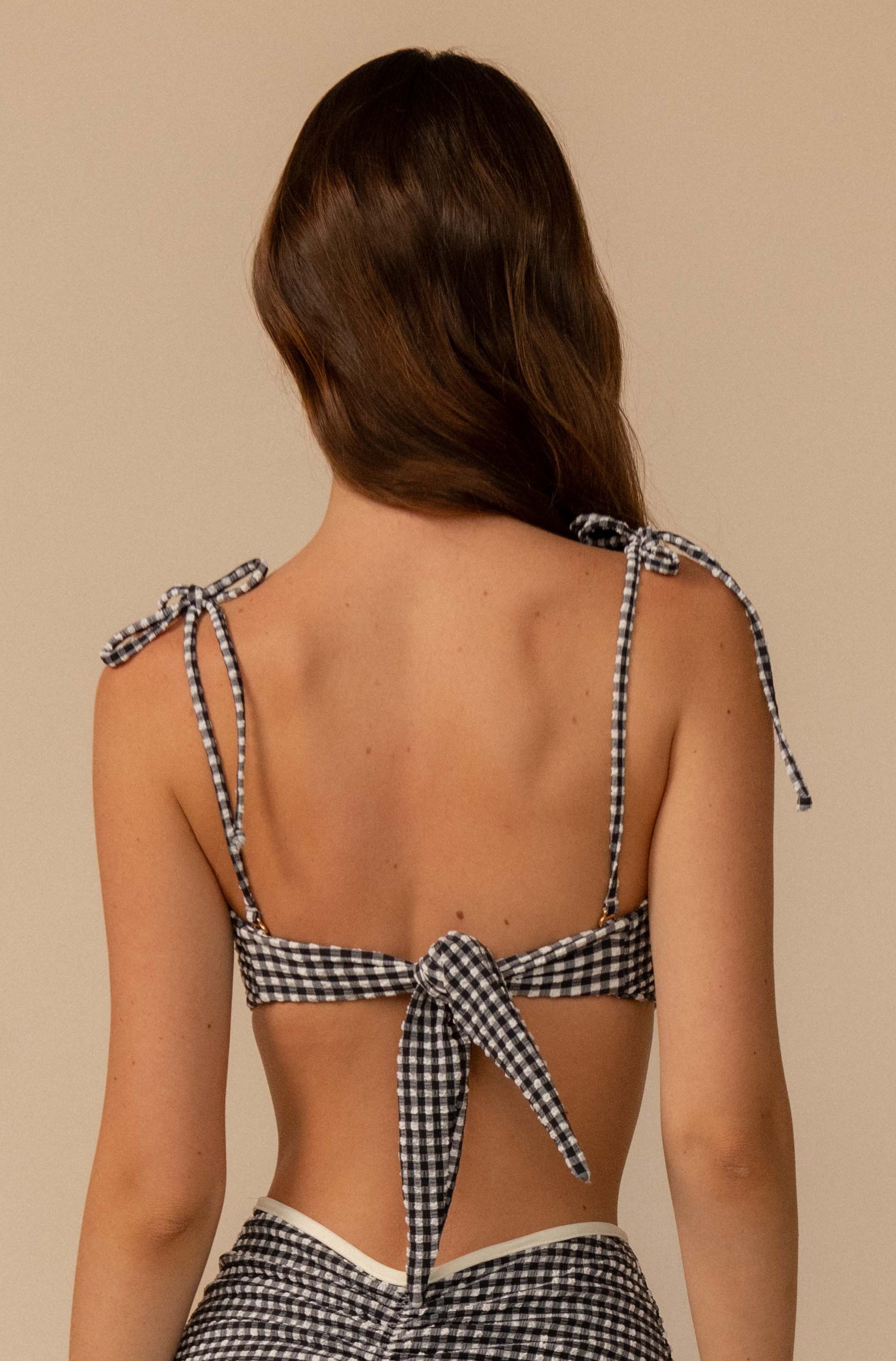 A woman, shown from the back against a neutral background, wears the Montce Black & White Gingham Tori Ties Bandeau featuring a sweetheart neckline and tied shoulder straps forming a large bow.