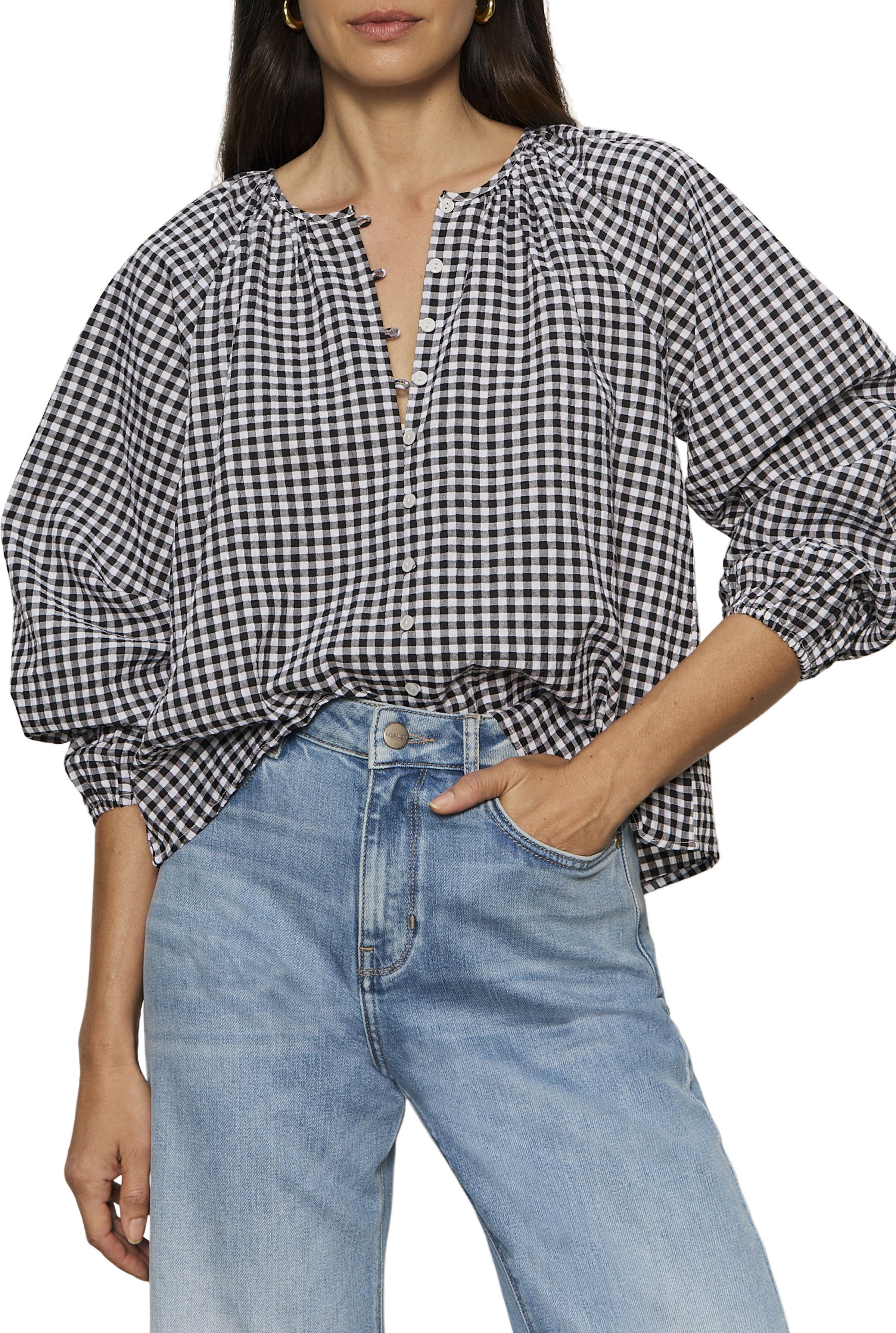 A woman wears the Perfect Gingham Button Blouse by Sanctuary in black and white with a relaxed fit, styled with light-wash high-waisted jeans.