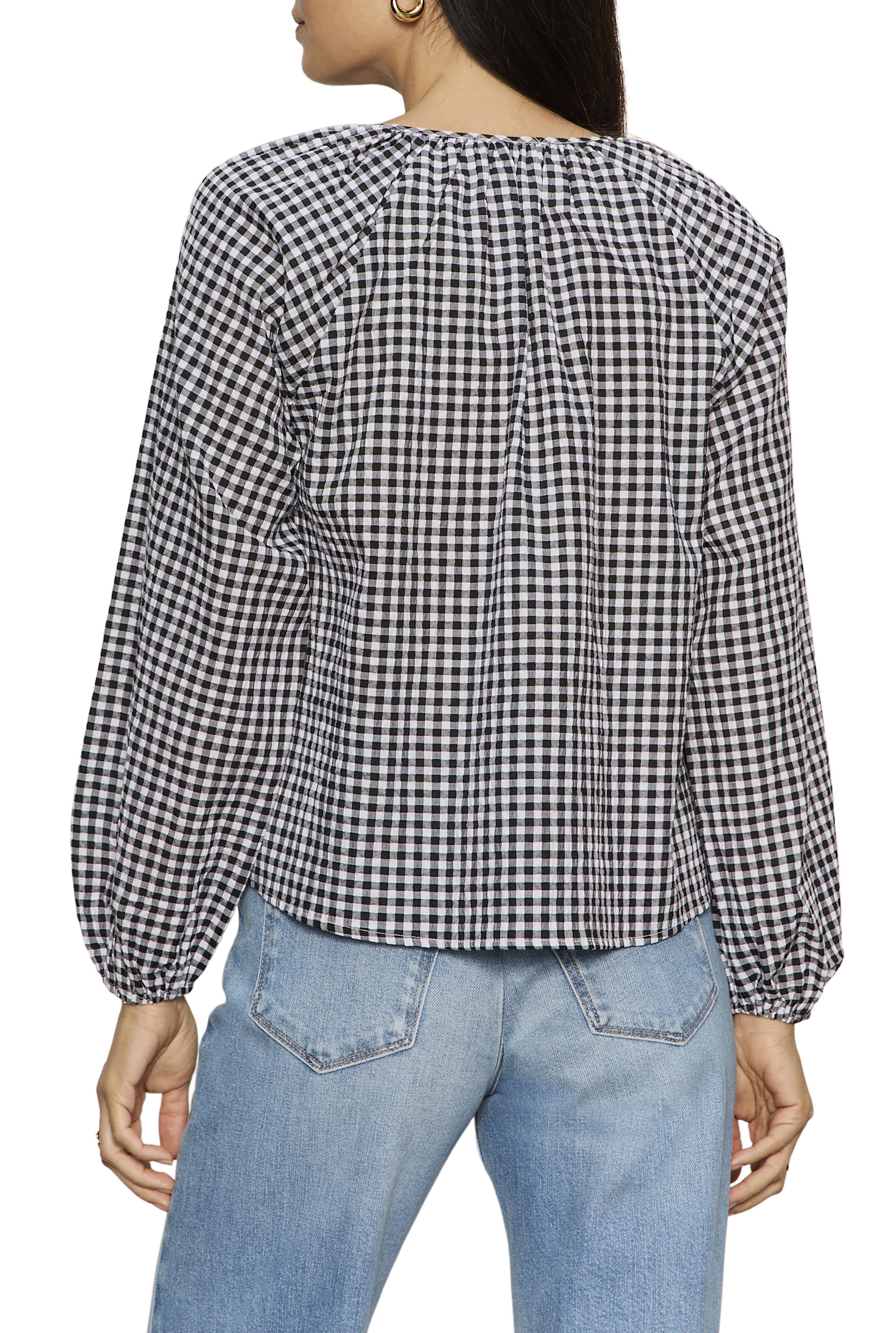 A woman is shown from the back wearing a black-and-white Perfect Gingham Button Blouse by Sanctuary with long sleeves and light blue jeans.