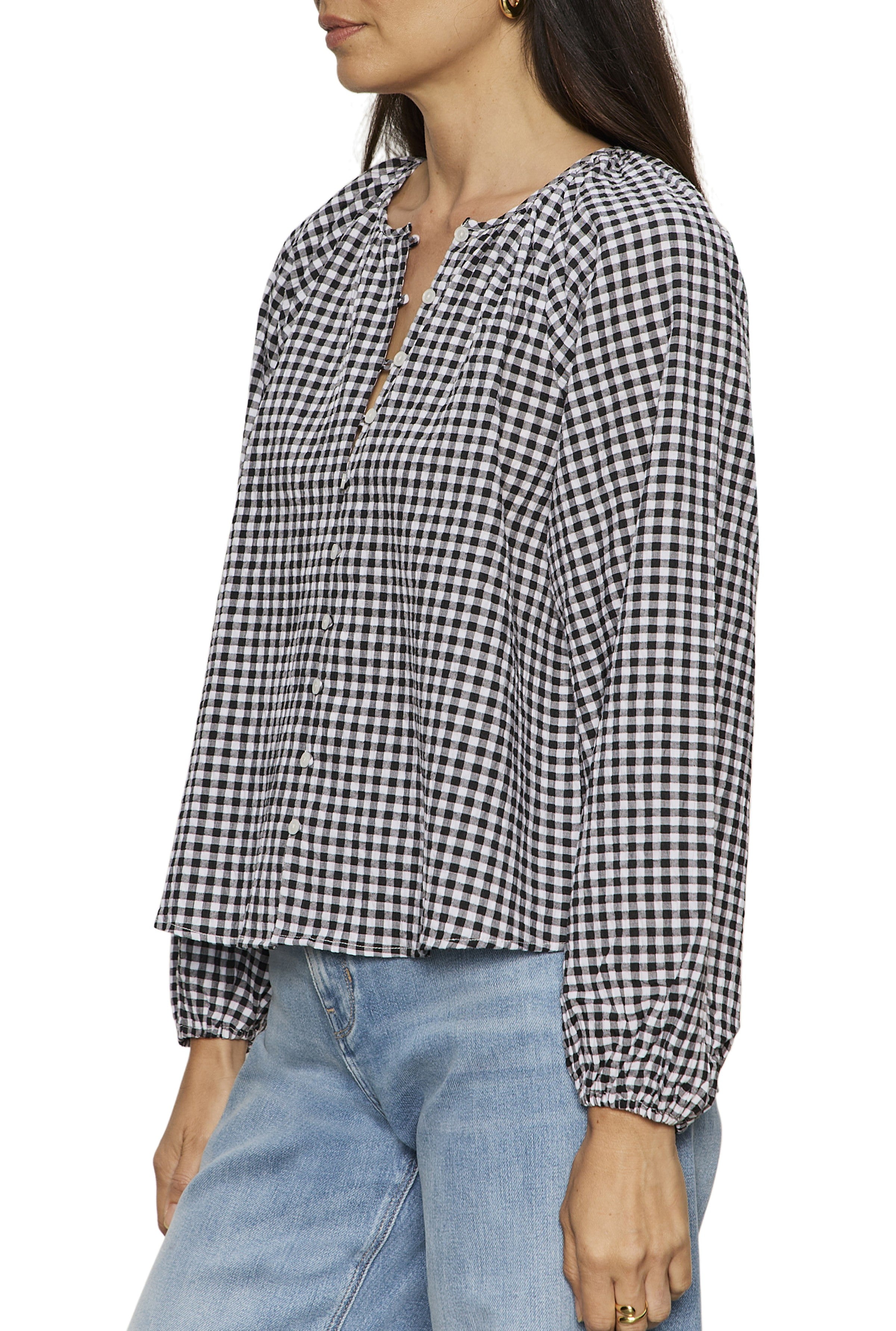 A woman with long, dark hair is shown from the side wearing the Sanctuary Perfect Gingham Button Blouse in black and white, paired with light blue jeans.