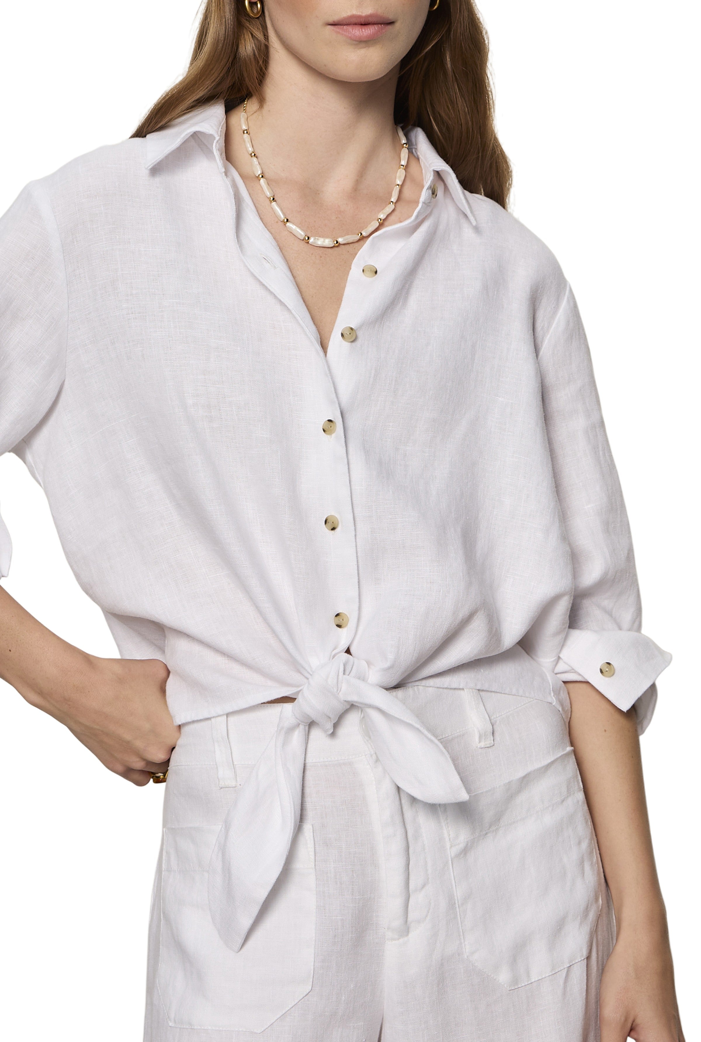 A woman wears the Sanctuary More Love Linen Tie Top with rolled sleeves, styled with matching high-waisted pants and a beaded necklace. Her face is partially out of frame.