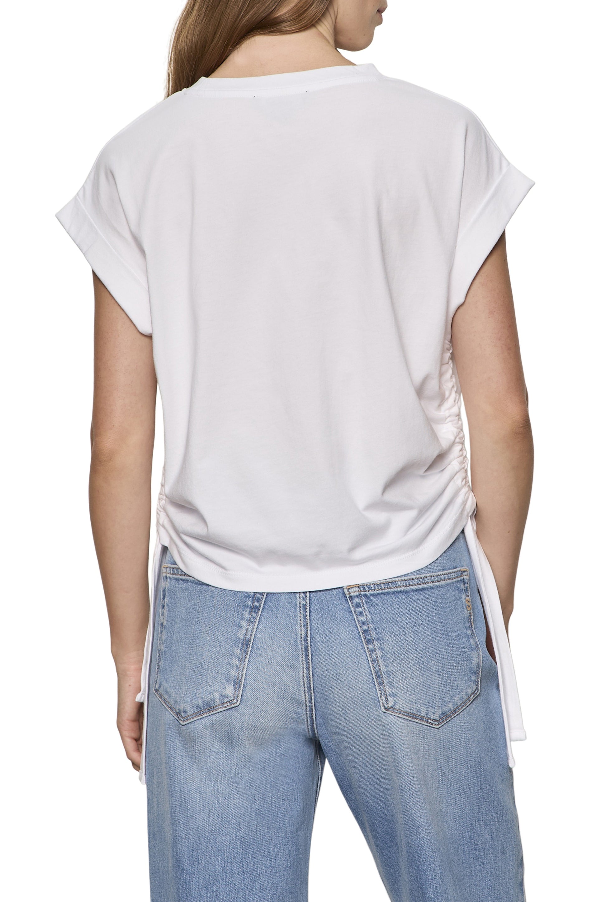 Model shown from the back wearing Sanctuary's All Day Ruched Tee—a white, short-sleeve top with adjustable side ruching and relaxed fit—paired with light blue high-waisted jeans against a white background.
