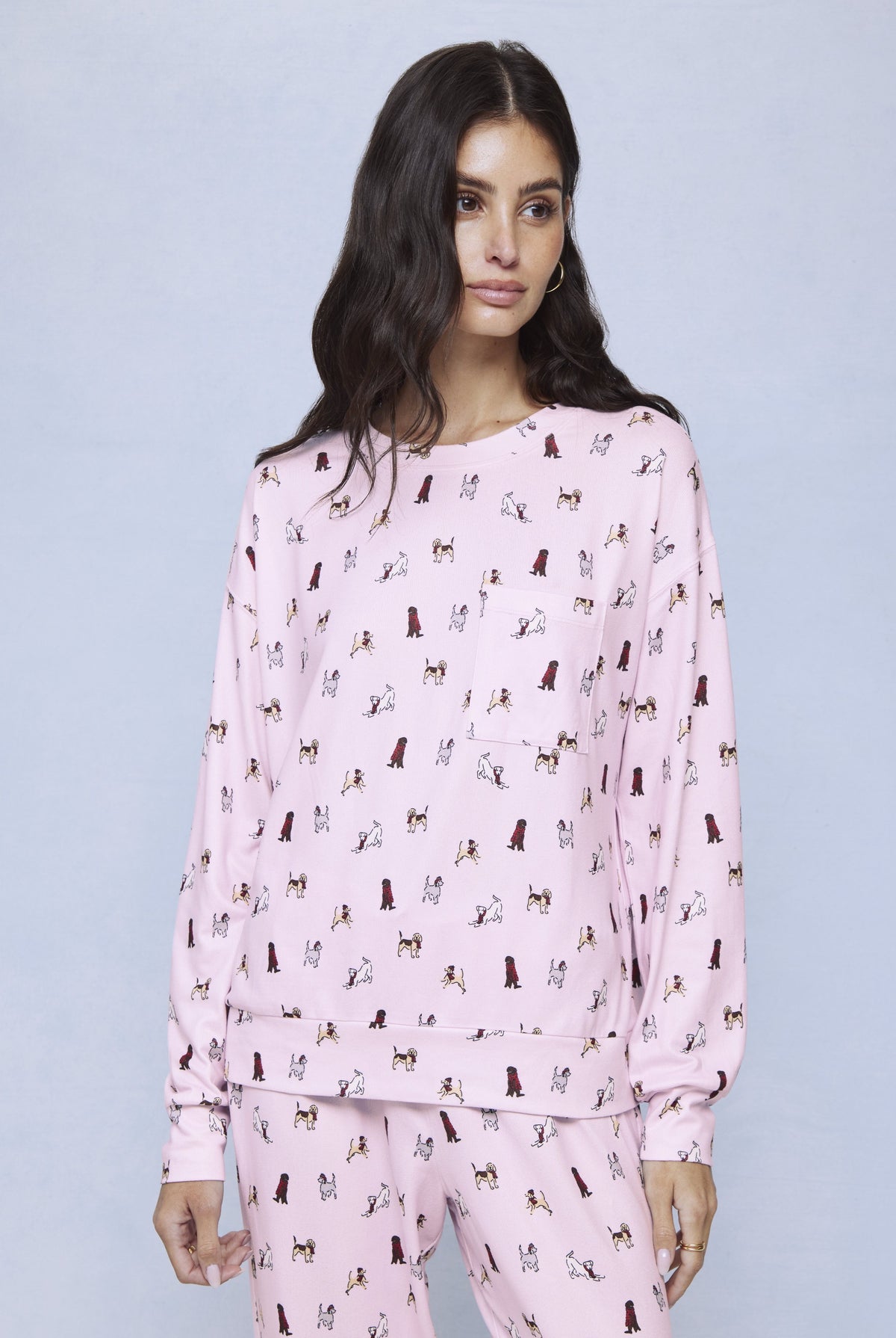 Pink jersey set with allover dog print, consisting of long-sleeve top and matching pants.