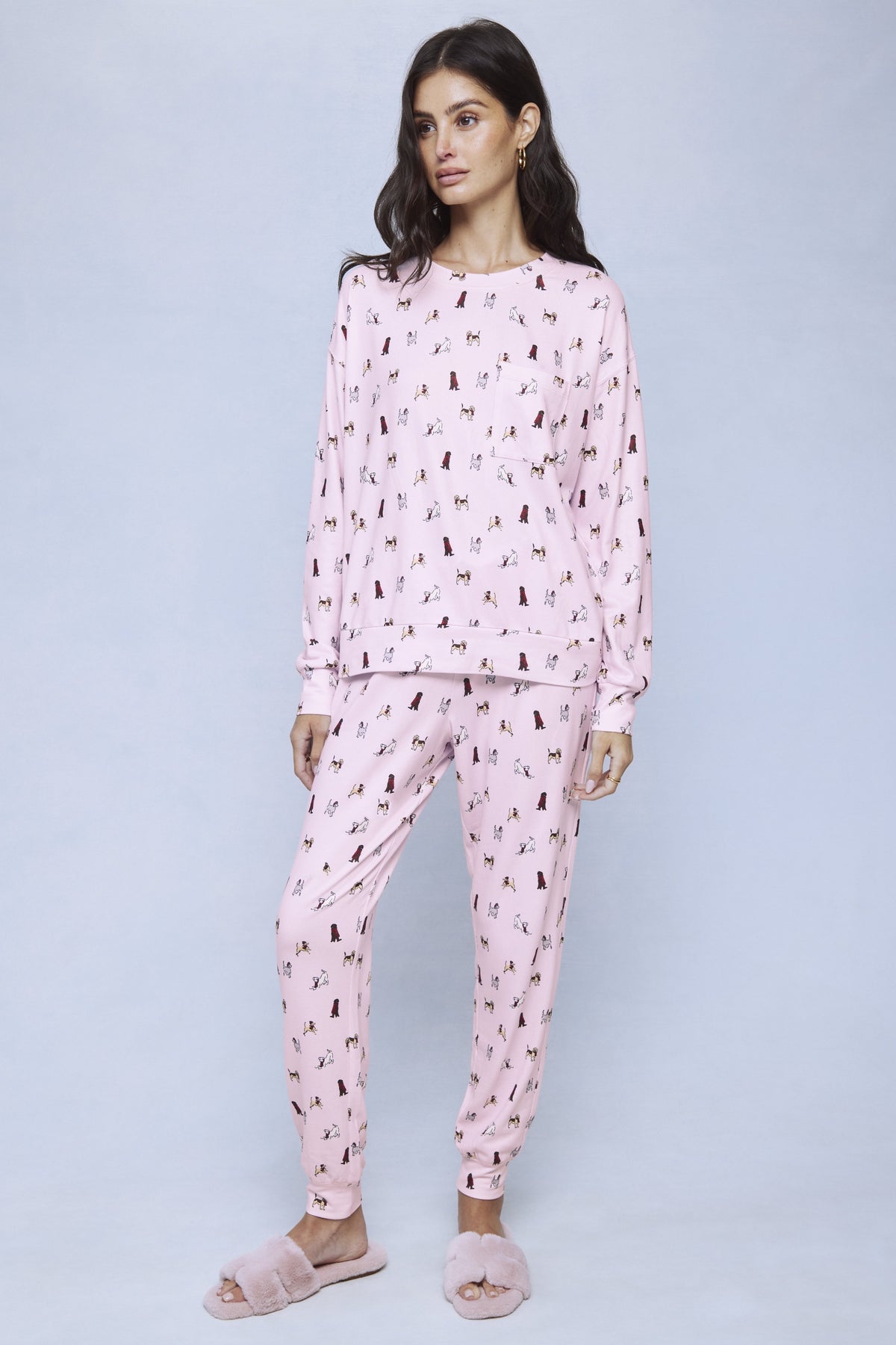 Pink jersey pajama set with scattered brown dog print throughout sweatshirt and matching pants.