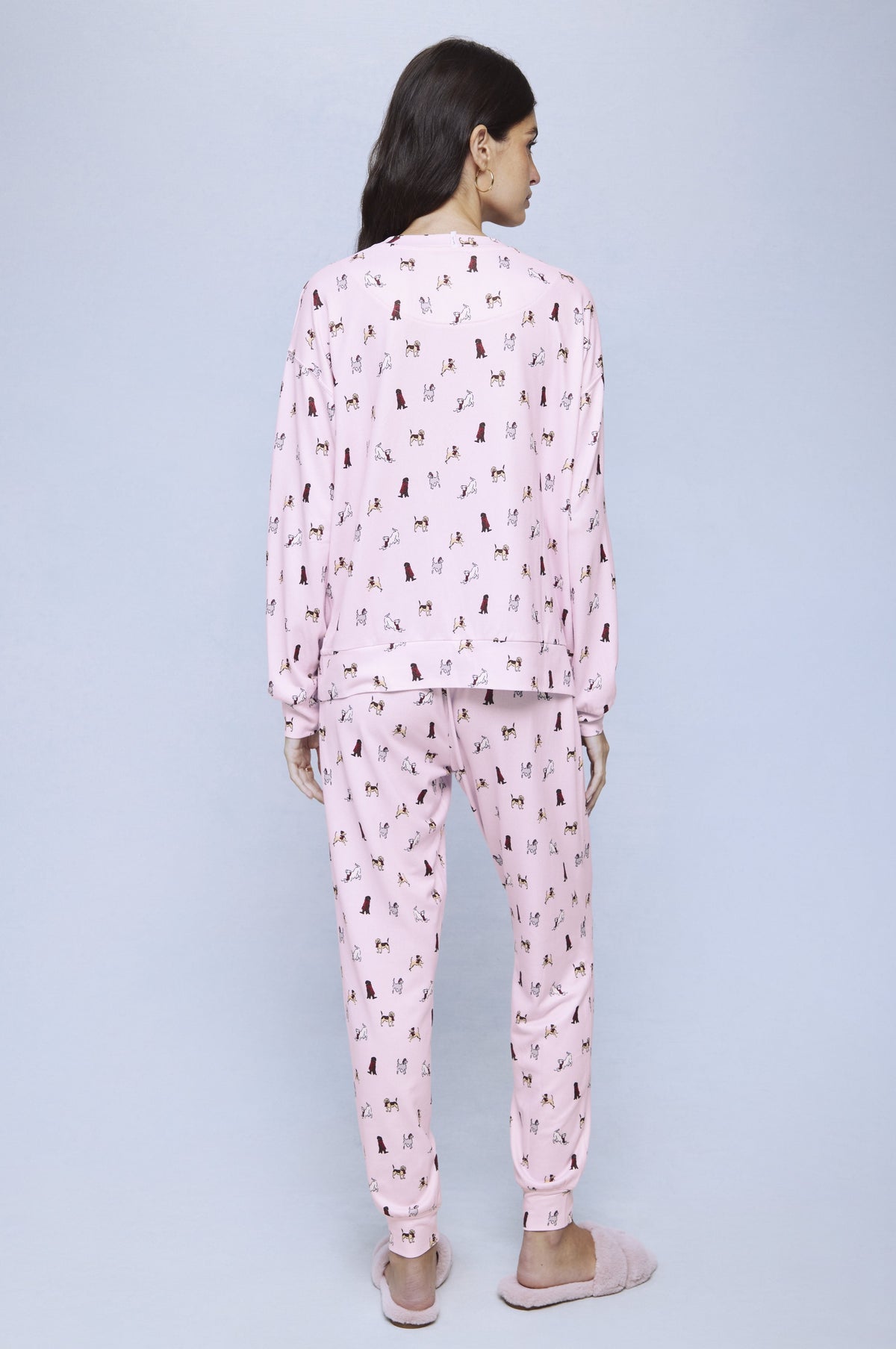 Pink jersey pajama set with all-over dog print, shown from back on model.