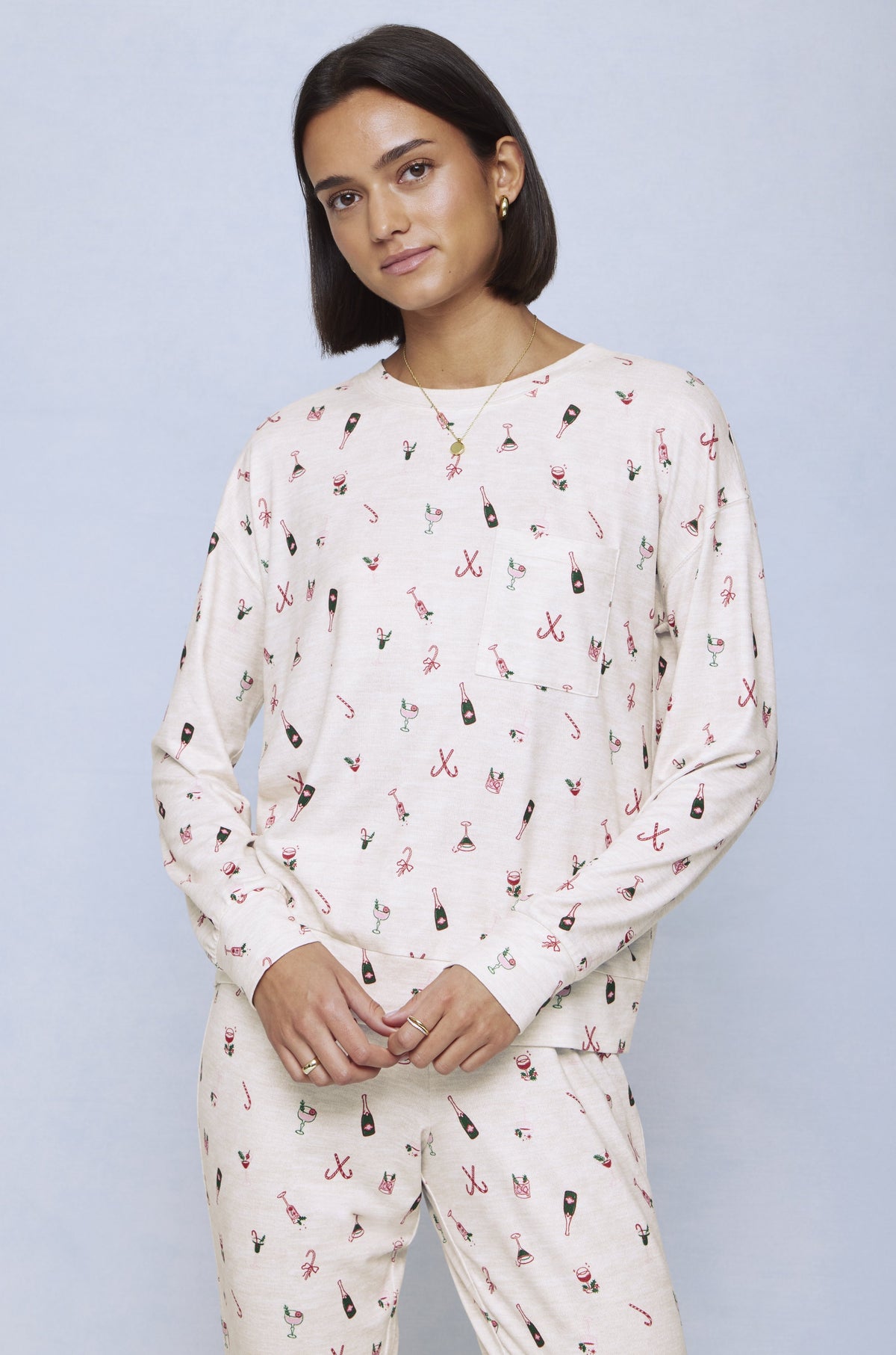 Cream jersey set with allover Christmas cocktail print including champagne bottles, candy canes, and festive motifs.