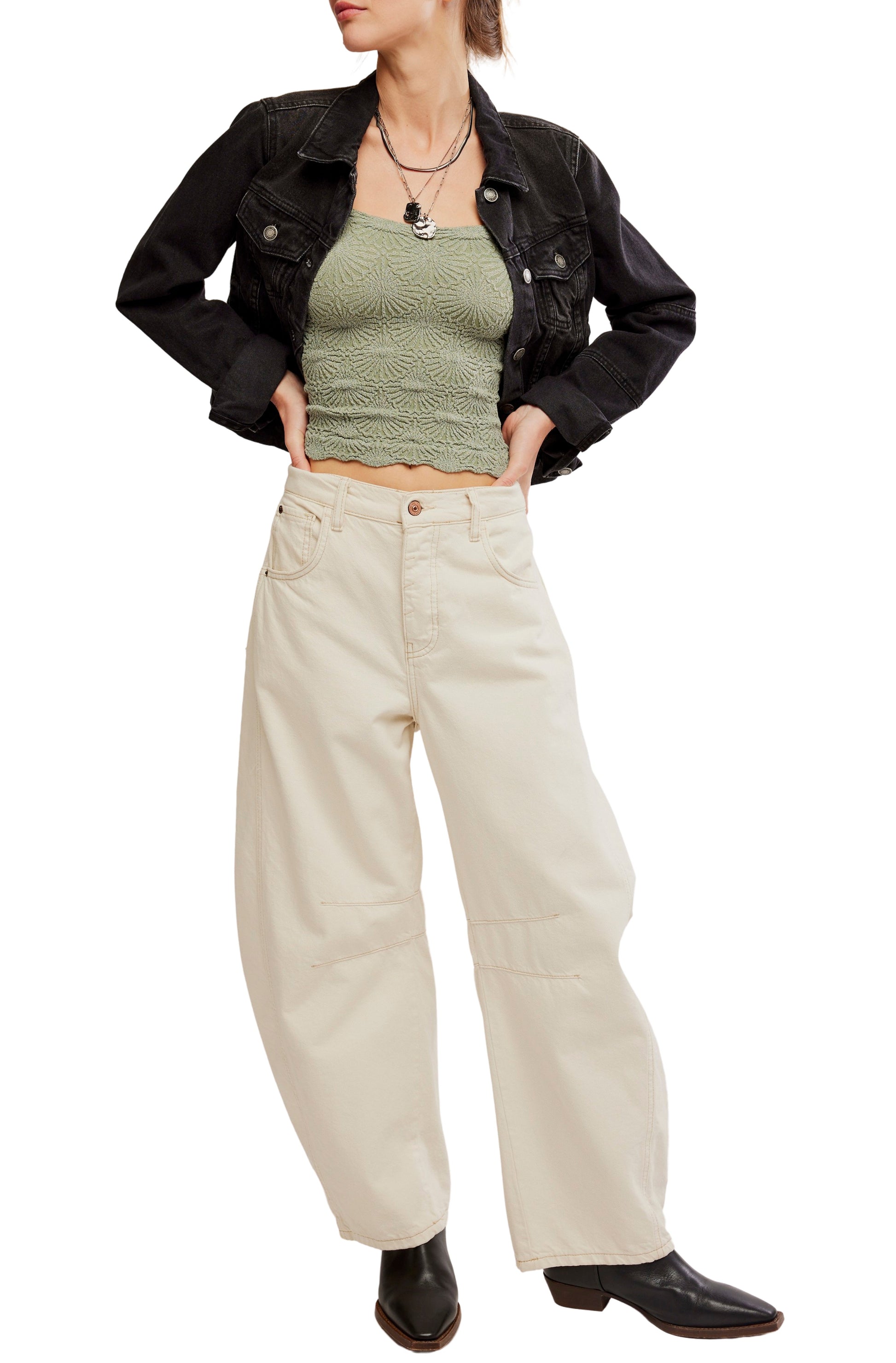 Wearing the Free People Love Letter Cami, a cropped black denim jacket, high-waisted wide-leg beige pants, and black boots with layered necklaces.