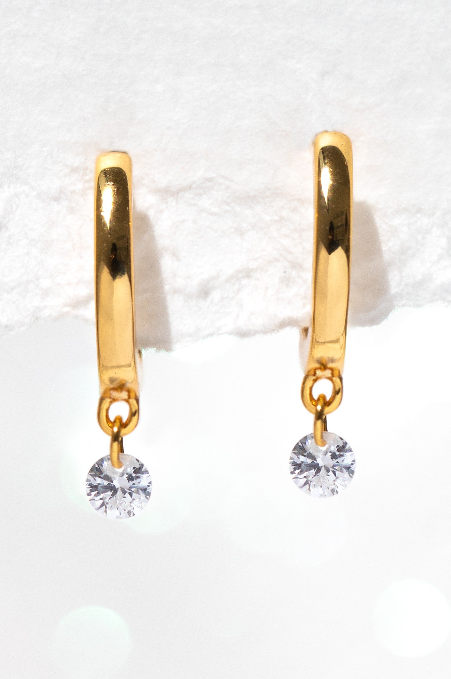 Girls Crew's Dew You Hoops are gold 18k gold plated earrings, each with a round cubic zirconia dangle, shown against a soft white background.