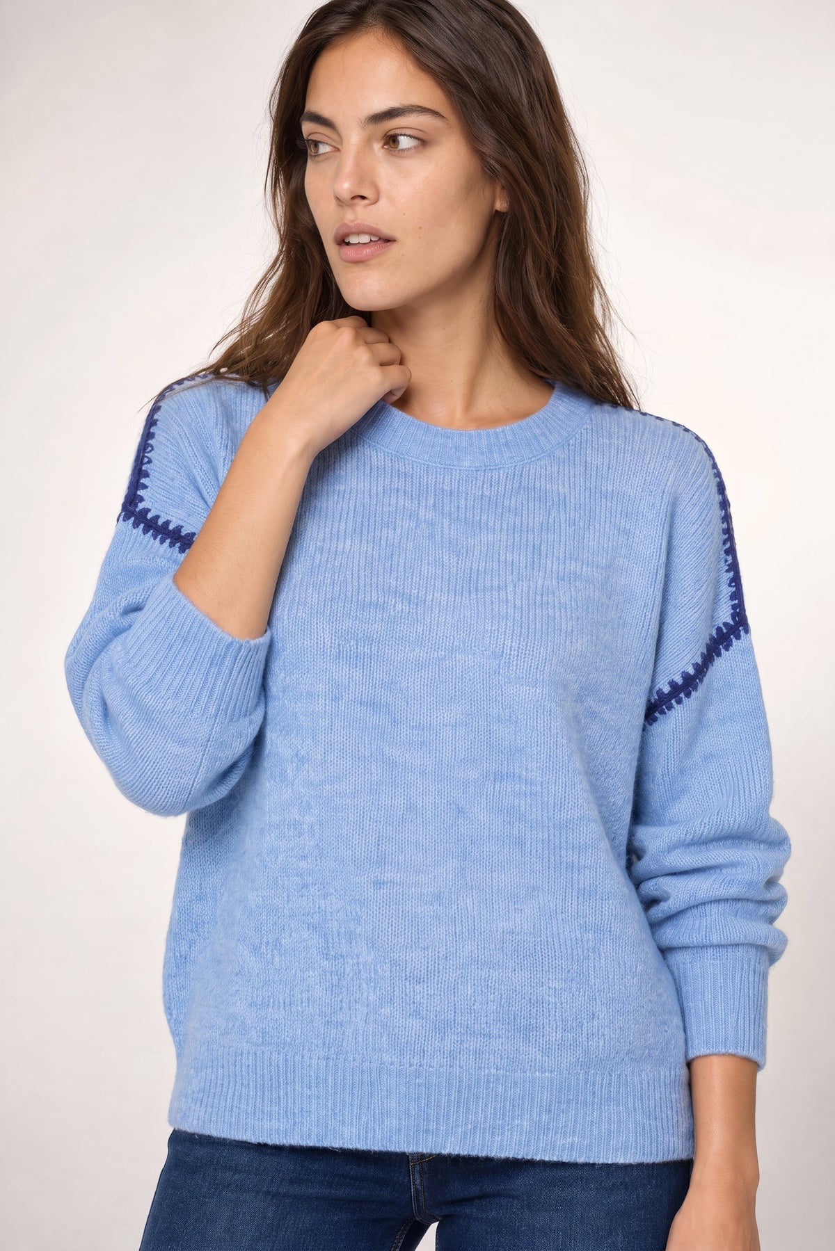 Light blue ribbed sweater with navy stitching detail on the sleeves and crew neckline.