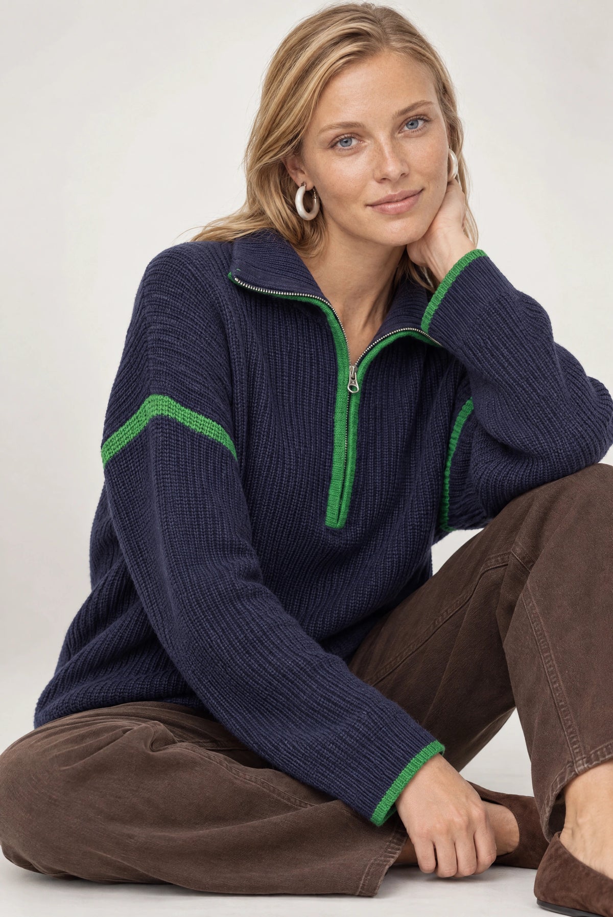 Navy ribbed half-zip sweater with green contrast trim on collar, sleeves, and cuffs.