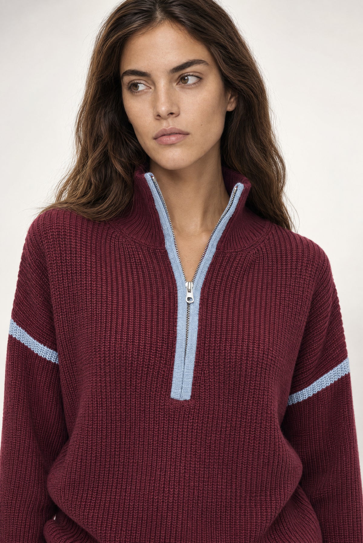 Burgundy ribbed half-zip sweater with light blue contrast trim on the collar and sleeves.