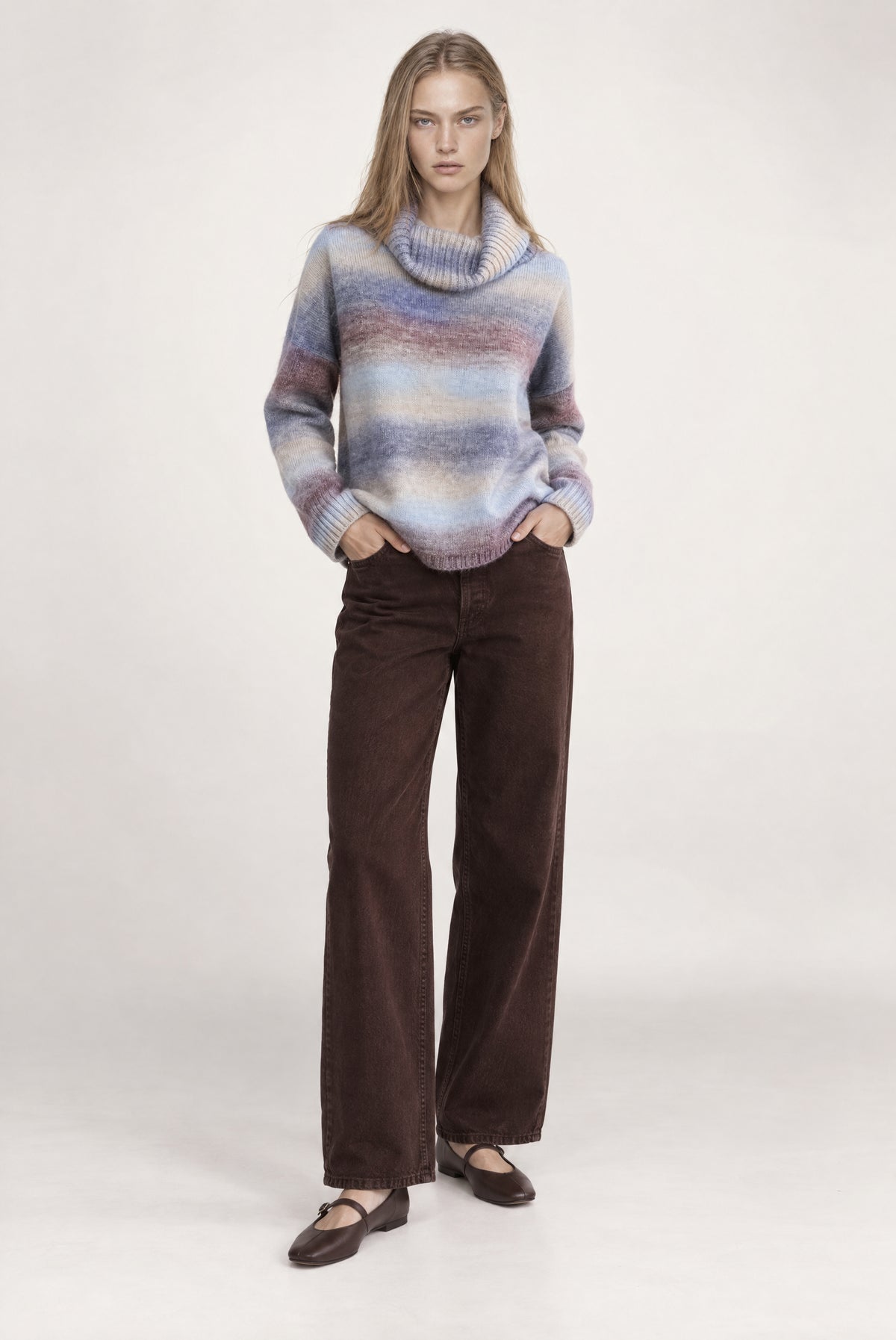 Turtleneck sweater with horizontal stripes in blue, purple, and cream, paired with brown denim jeans.