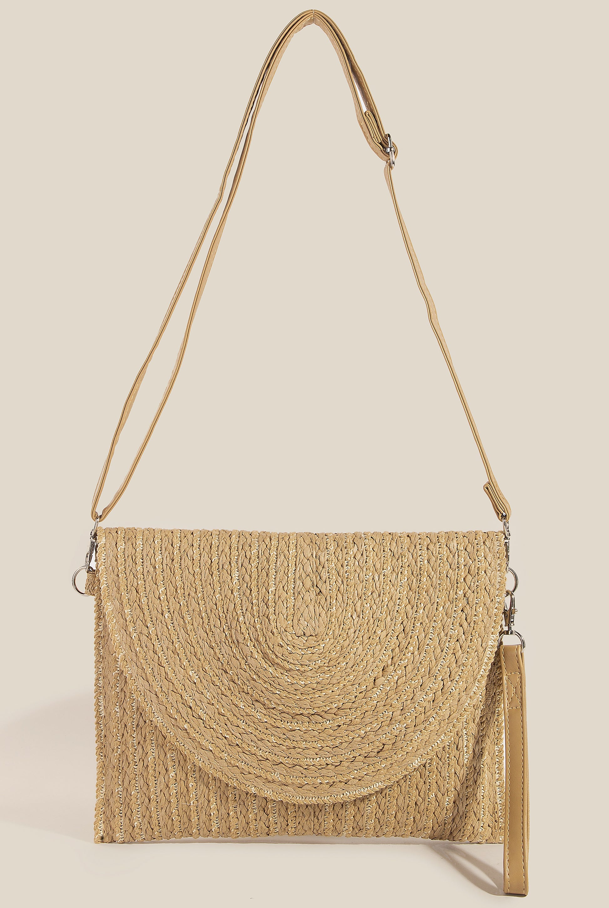 The South Moon Under Straw Woven Clutch in tan features a curved flap, gold accents, detachable wristlet strap, and adjustable shoulder strap, shown against a plain light background.