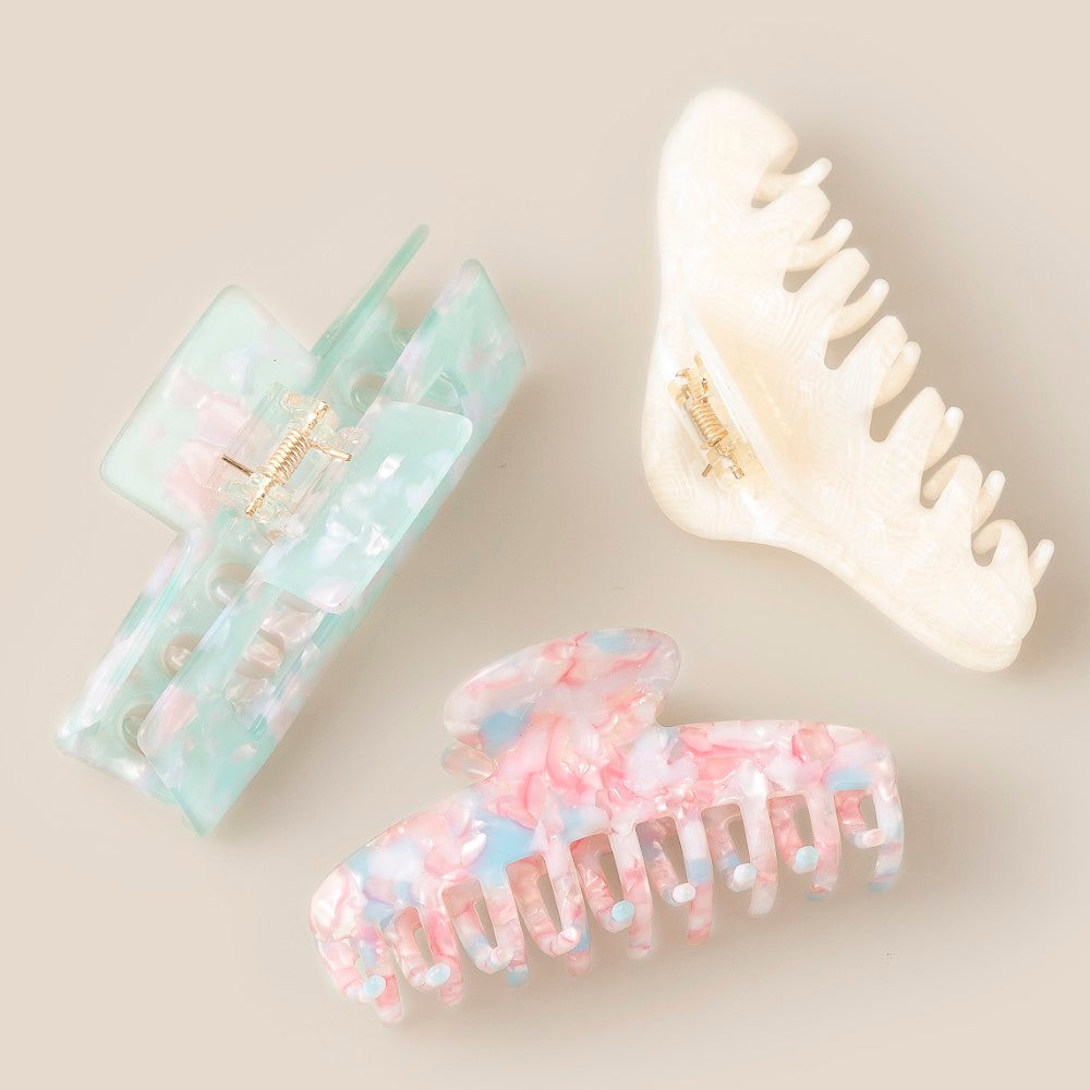 Three Medium Assorted Clips by South Moon Under are displayed on a neutral background. These Pink Multi hair clips offer a strong grip and stylish pastel designs—perfect for everyday wear.