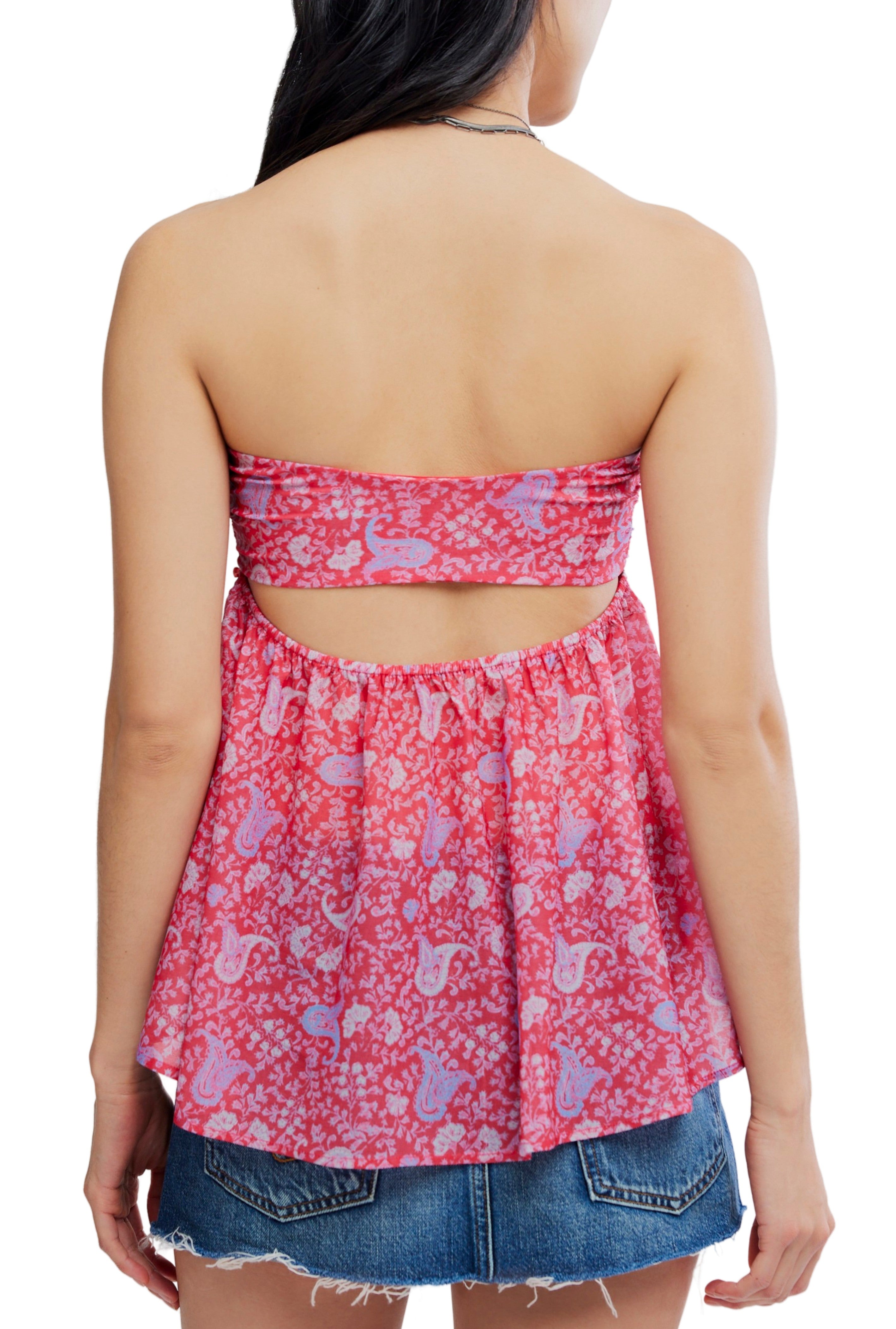 A person wears the Free People Malia Tube, a pink and purple patterned sleeveless polyester strapless top with open back cutout, paired with a short denim skirt. Back view highlights the detail. OB2517410; machine wash cold recommended.