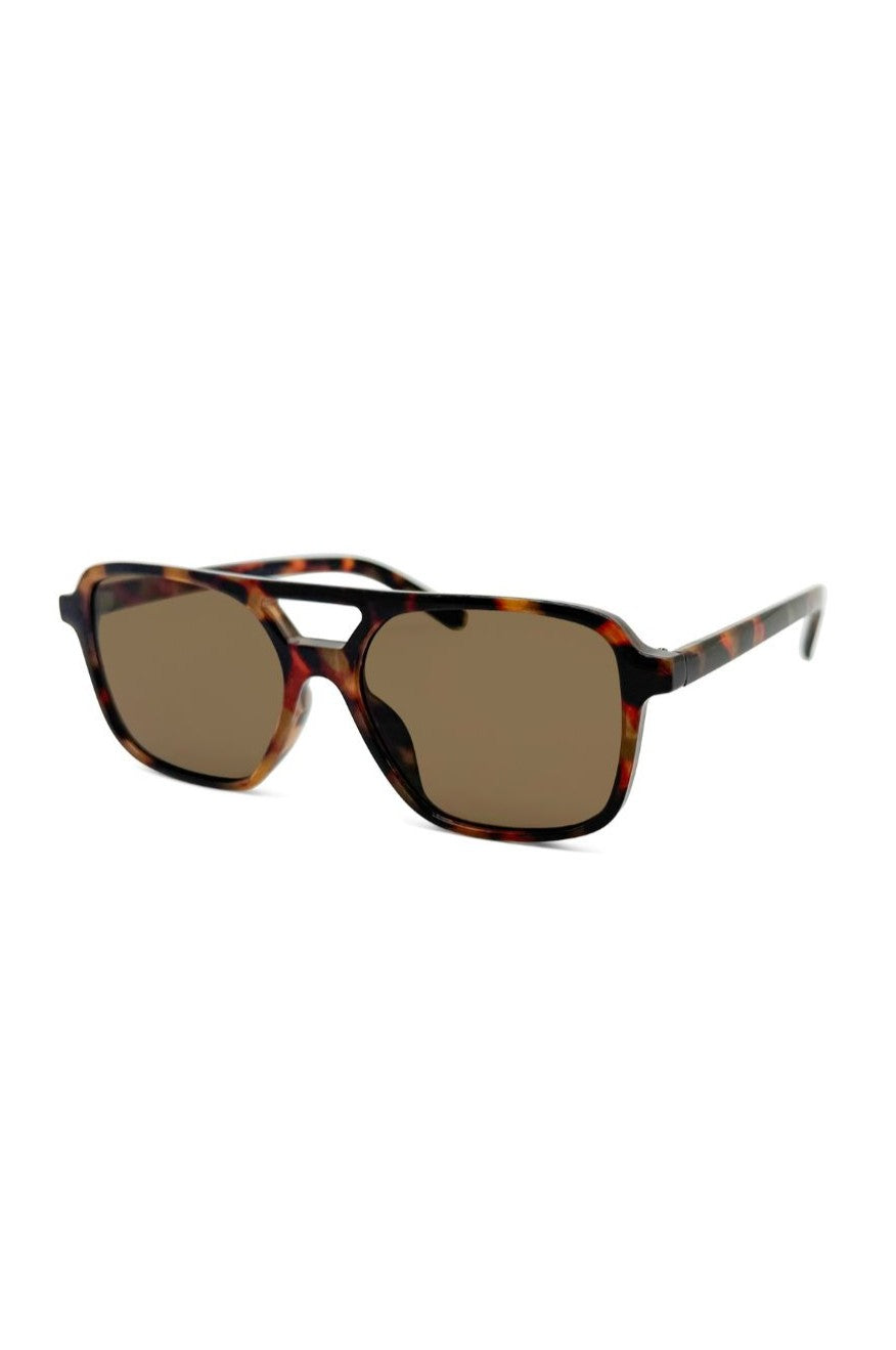 The Onyx Sunnies In Tortoise by South Moon Under feature a brown multi tortoiseshell rectangular plastic frame with monotone brown UV-protected lenses, displayed at an angle on a white background.