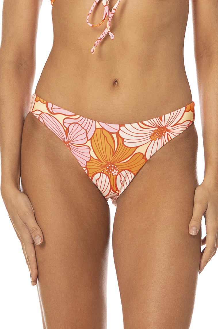 A model wears the Maaji Retro Bloom Sublimity Bottom in Pink Multi. The cheeky coverage bikini bottom features a vibrant, playful pattern. The cropped image highlights the lively swimwear style from shoulders to upper thighs.