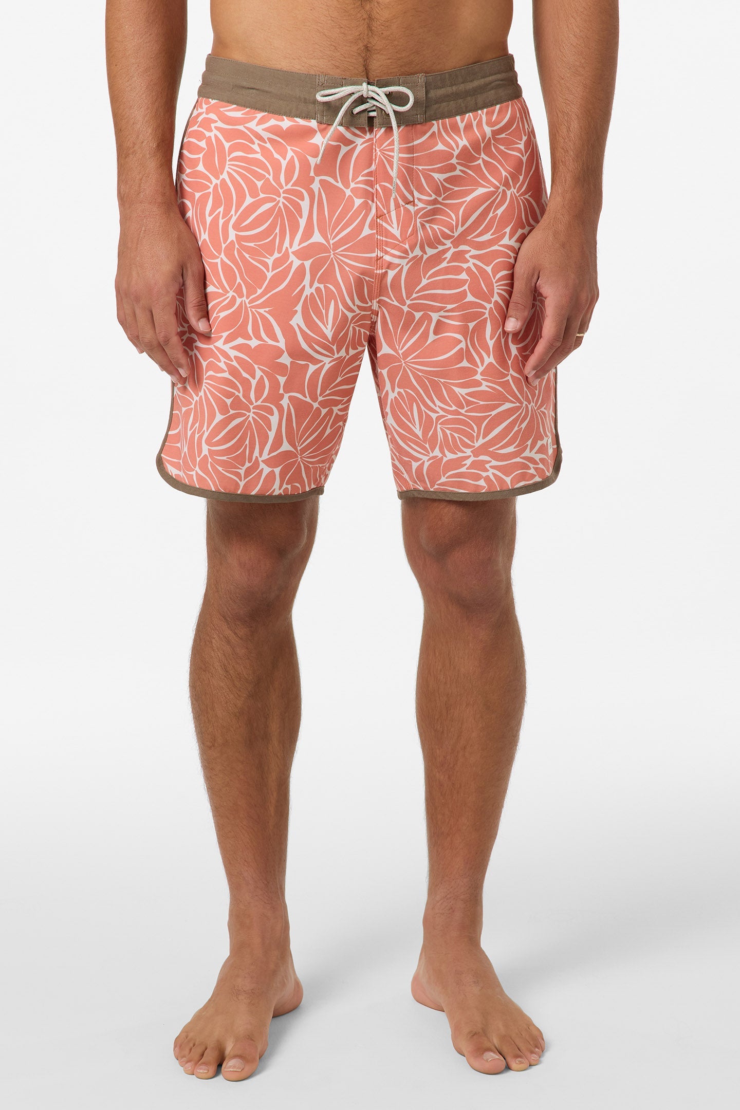 A person stands barefoot wearing O'Neill Cruzer Scallop 18 In Boardshorts in Orange Multi, shown from waist to feet against a plain background.