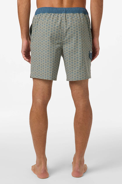 A man stands barefoot facing away, wearing O'Neill Hermosa Retro 17 In Swim Trunk with a blue waistband and right-side pocket. These water-resistant shorts have Hyperdry technology. Background is plain white.