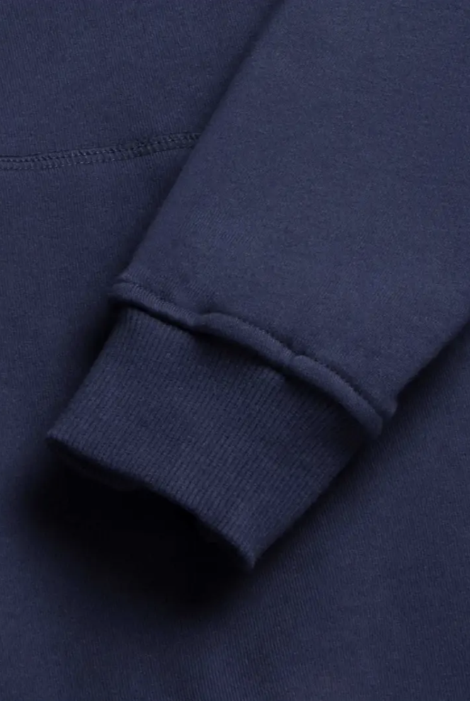 Close-up of the Marine Long Sleeve French Terry Hoodie's sleeve by Surfside Supply Co., featuring a ribbed cuff and ultra-soft cotton fabric texture in navy blue.