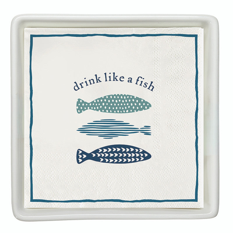 The Drink Like A Fish Napkin Set by Santa Barbara Design Studio features white napkins with blue fish illustrations and the phrase "drink like a fish," perfect coastal cocktail napkins for your next seaside gathering.