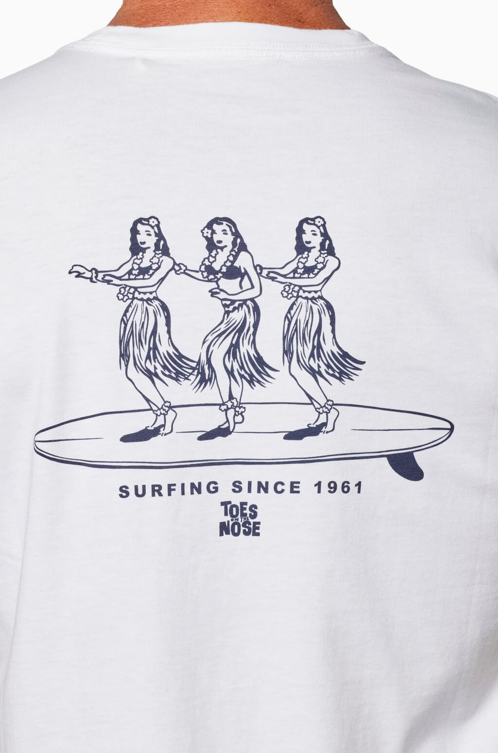 Back of the Hula Board Short Sleeve Tee by Toes on the Nose shows three hula dancers on a surfboard, “SURFING SINCE 1961” text, and the Toes on the Nose logo.