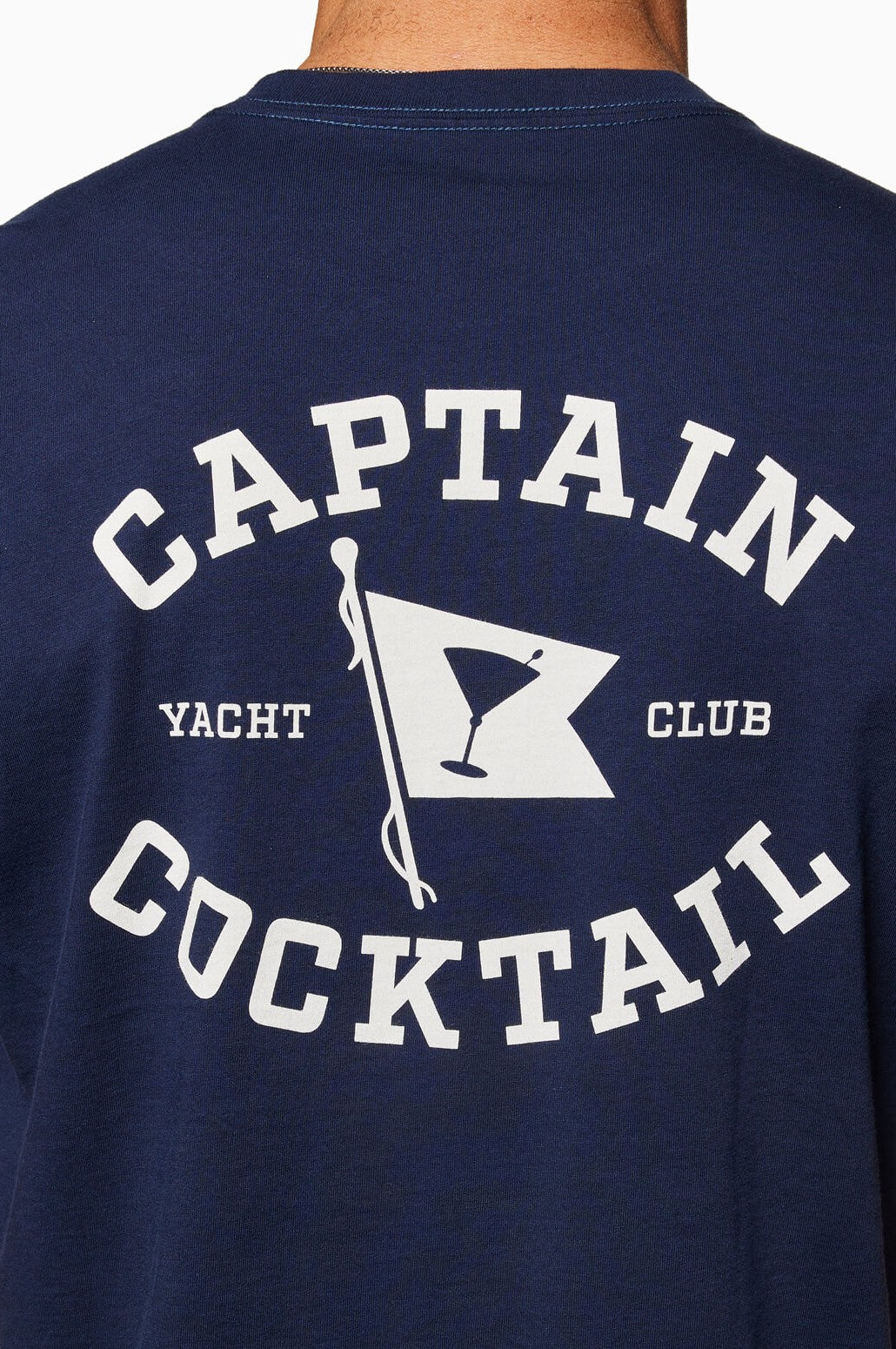 The Yacht Club Short Sleeve Tee by Toes on the Nose is a navy blue crewneck with "CAPTAIN COCKTAIL" and "YACHT CLUB" in white text around a cocktail flag graphic, made from soft Peruvian cotton.
