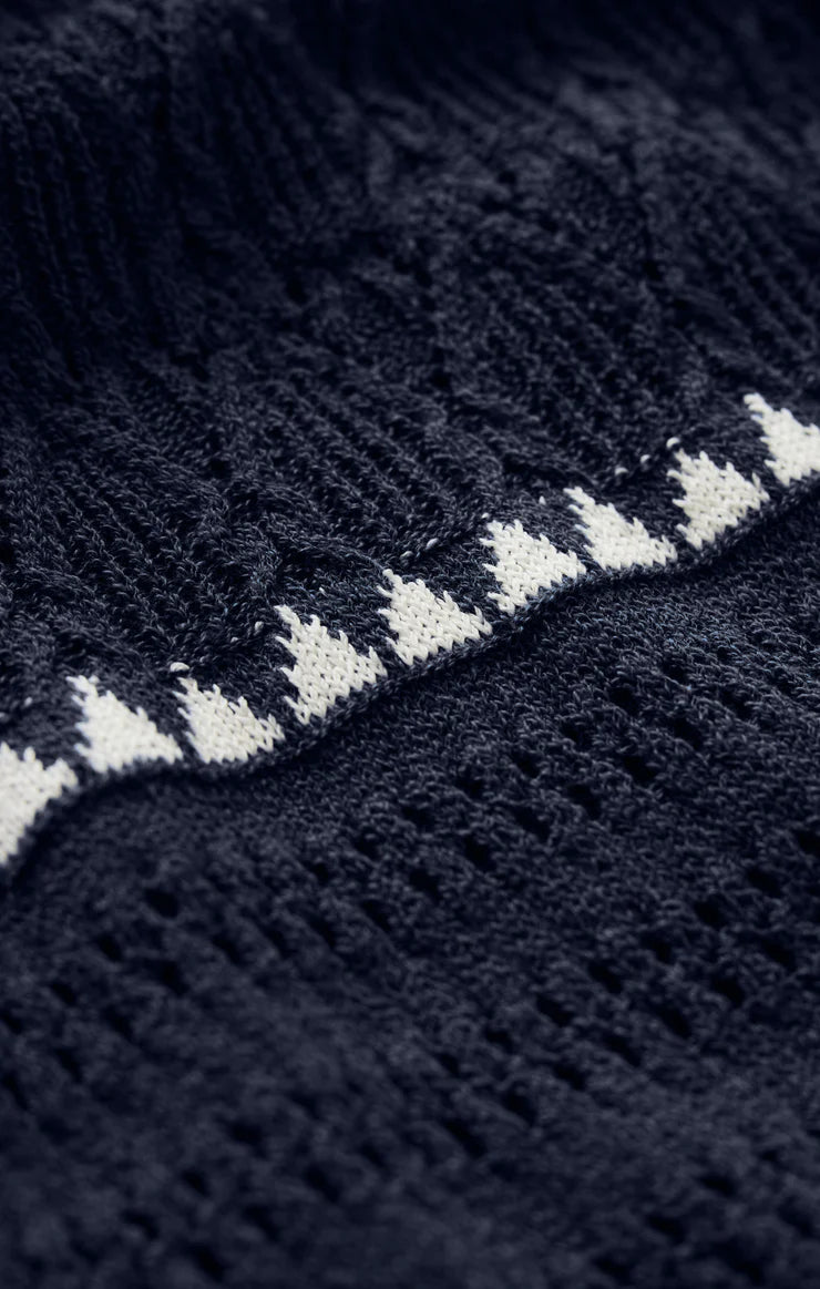 Close-up of the Catamaran Striped Maxi Dress by Z Supply, featuring dark blue knit fabric with a horizontal white zigzag stripe, highlighting its textured and intricate knit details.