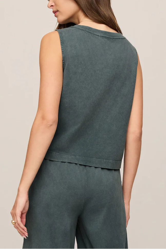 A woman is seen from the back in a relaxed fit Sloane V-neck Top in Emerald Cove by Z Supply, paired with matching high-waisted pants. Her long brown hair flows down her back against a neutral backdrop.