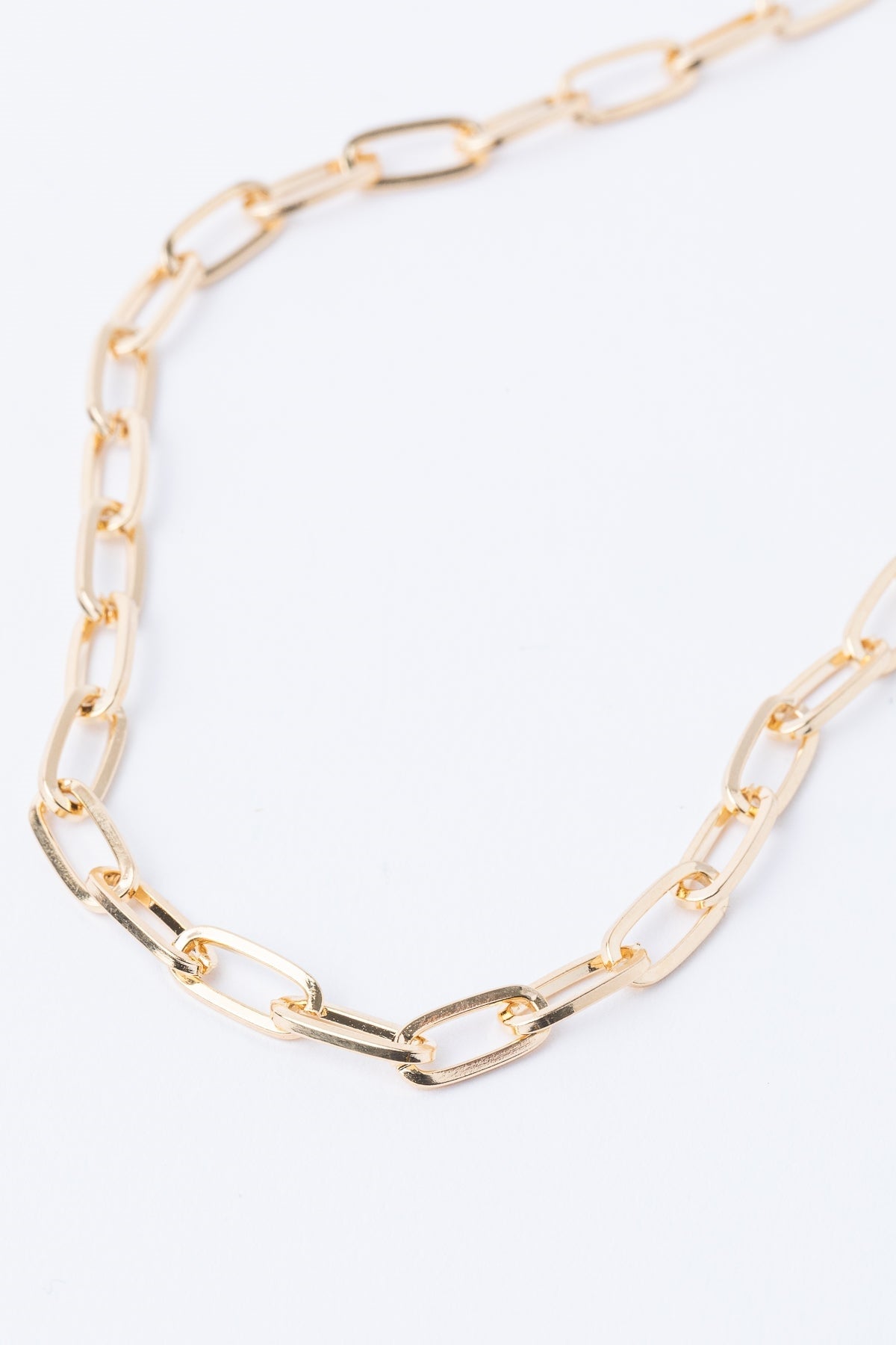 The South Moon Under Gold Chain Link Short Necklace features elongated oval links and a lustrous gold finish, elegantly displayed on a white background.