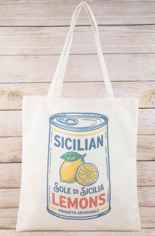 The South Moon Under Canvas Tote in Ivory Multi features a colorful can of Sicilian Lemons with a lemon and slice, plus Italian text “Sole di Sicilia” and “Prodotto Artigianale.” Style: MMA9334MU.