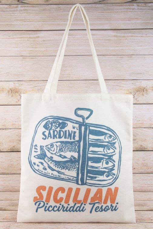 The South Moon Under Canvas Tote (Ivory Multi) features sardines in a tin can with “Sardine, Sicilian Picciriddi Tesori” in blue and orange on the front, displayed against rustic wooden planks.
