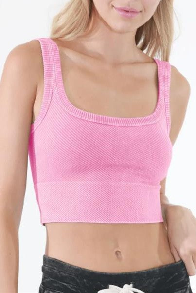 A woman wearing the Vintage Chevron Crop Top in Vintage Azalea by Niki Biki. Only her upper body is visible as she stands against a plain white background.
